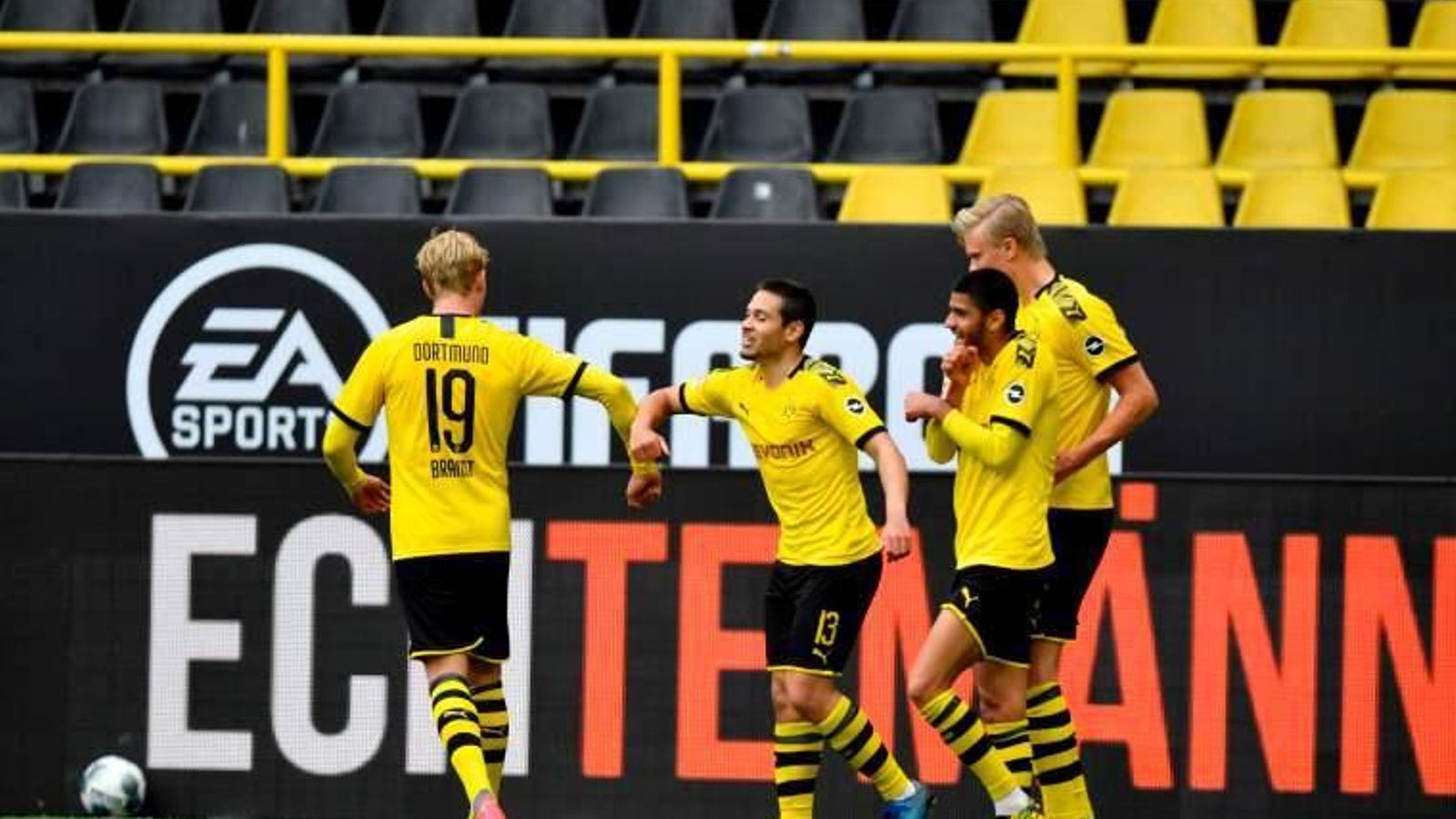 Brandt felicita con el codo a Guerreiro, autor de dos goles del Dortmund, en un estadio vacío.