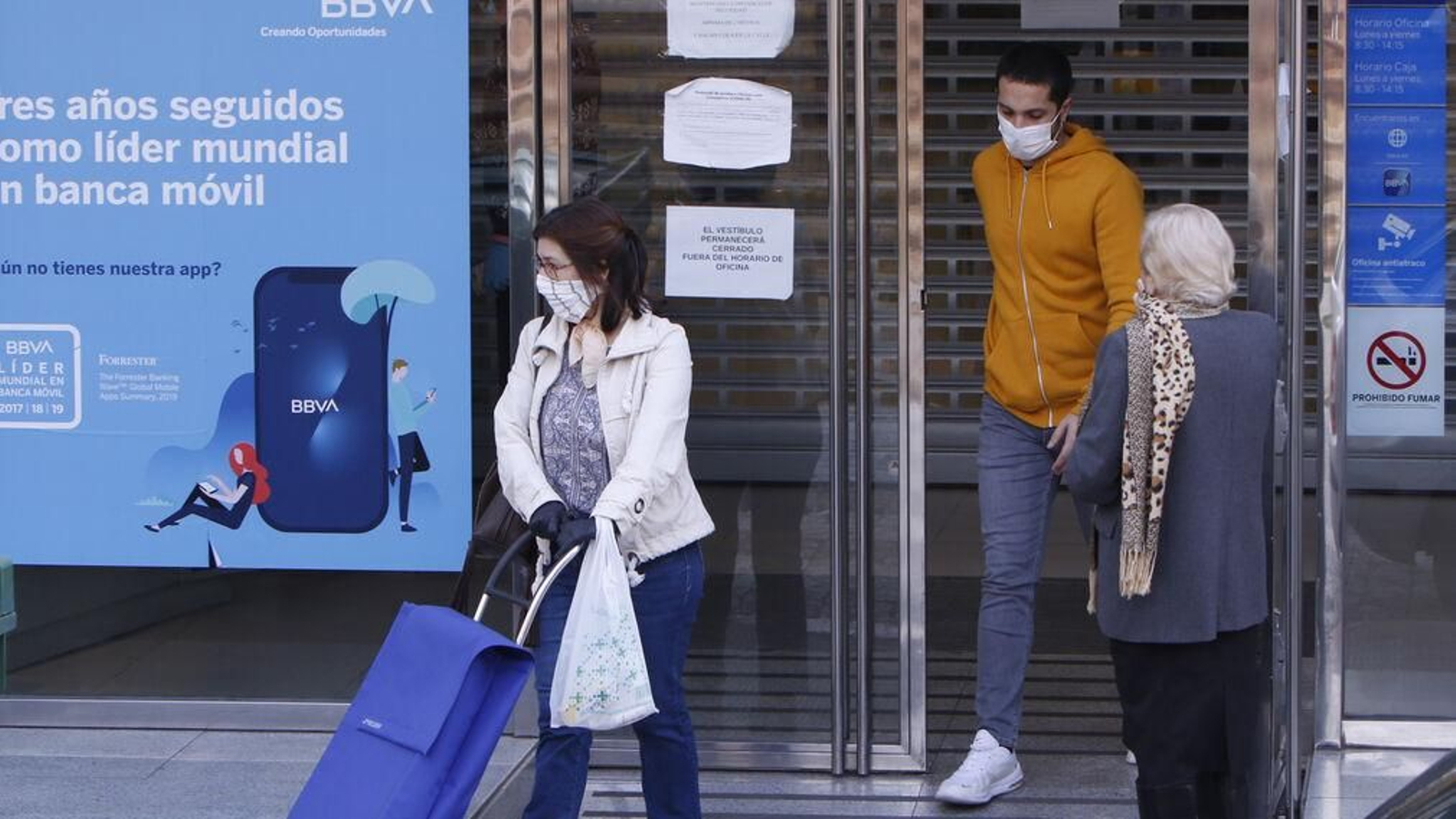 Varias personas cerca de un cajero, durante el anterior confinamiento, en Alcalá de Guadaíra.