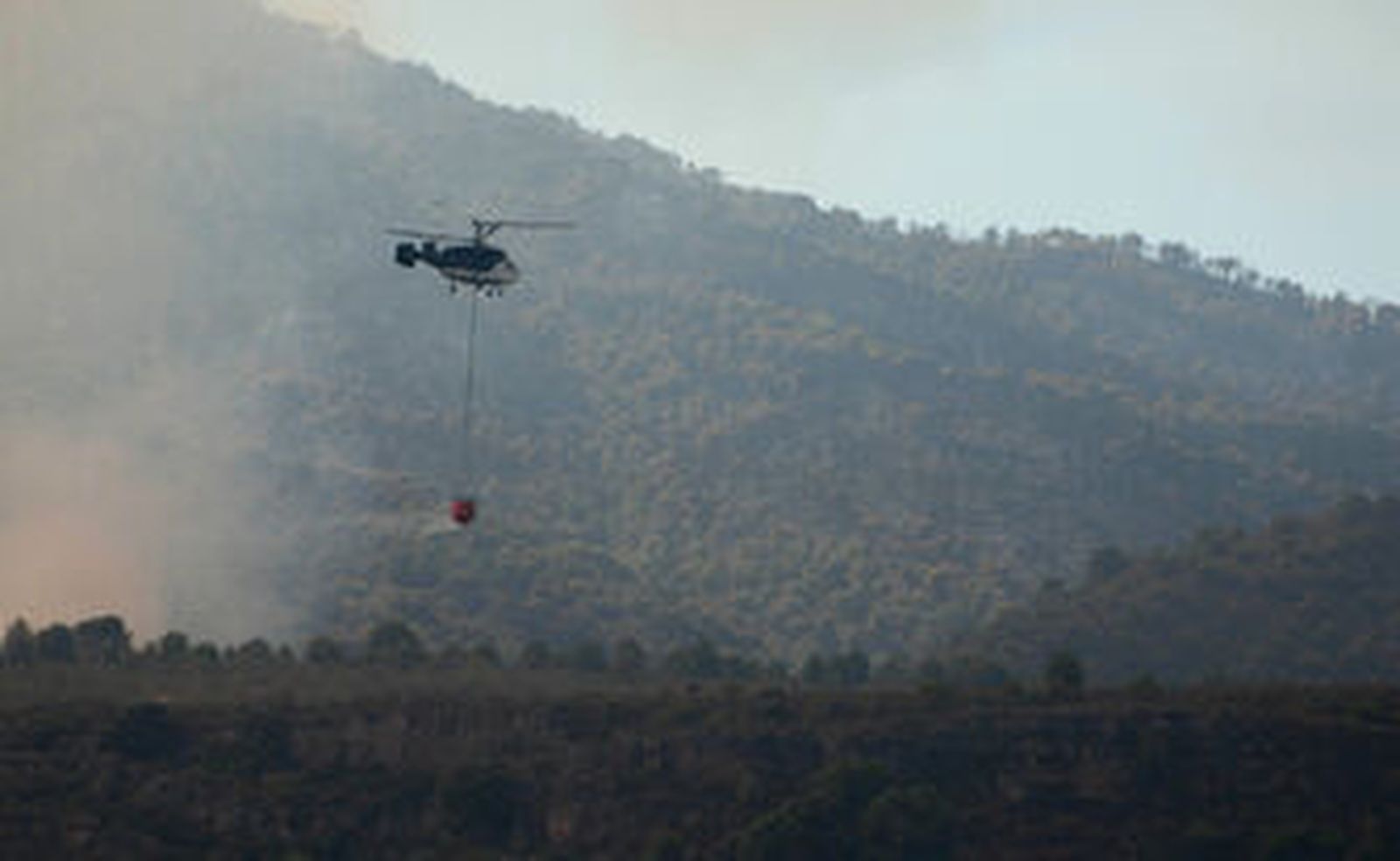 Evacuado al hospital un bombero por el incendio de Granada, que sigue activo