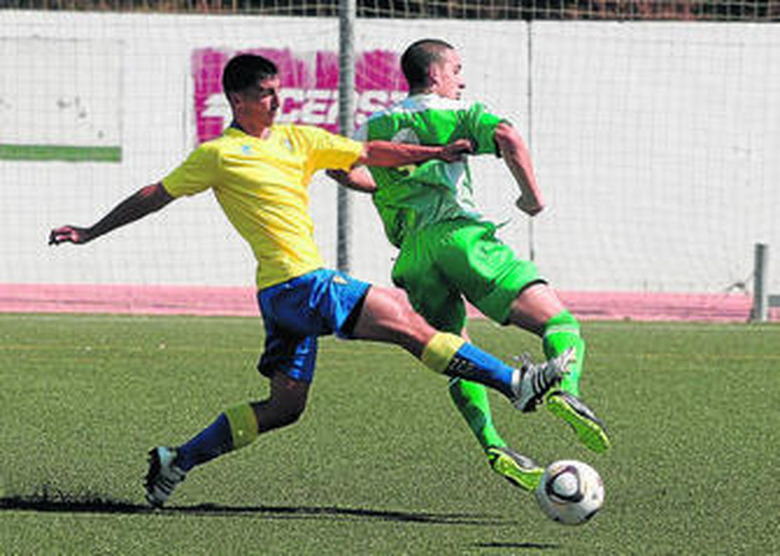 El verderón Cristian Núñez recibe la entrada de un zaguero cadista.
