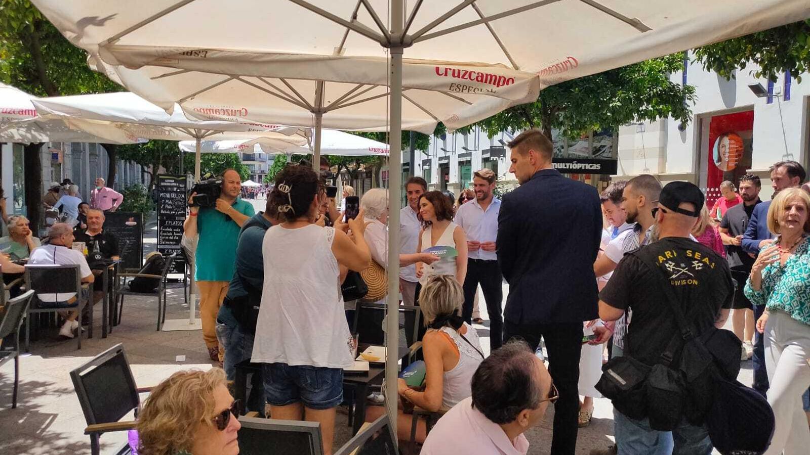 Ayuso saluda a una mujer, en un bar de la calle Larga.