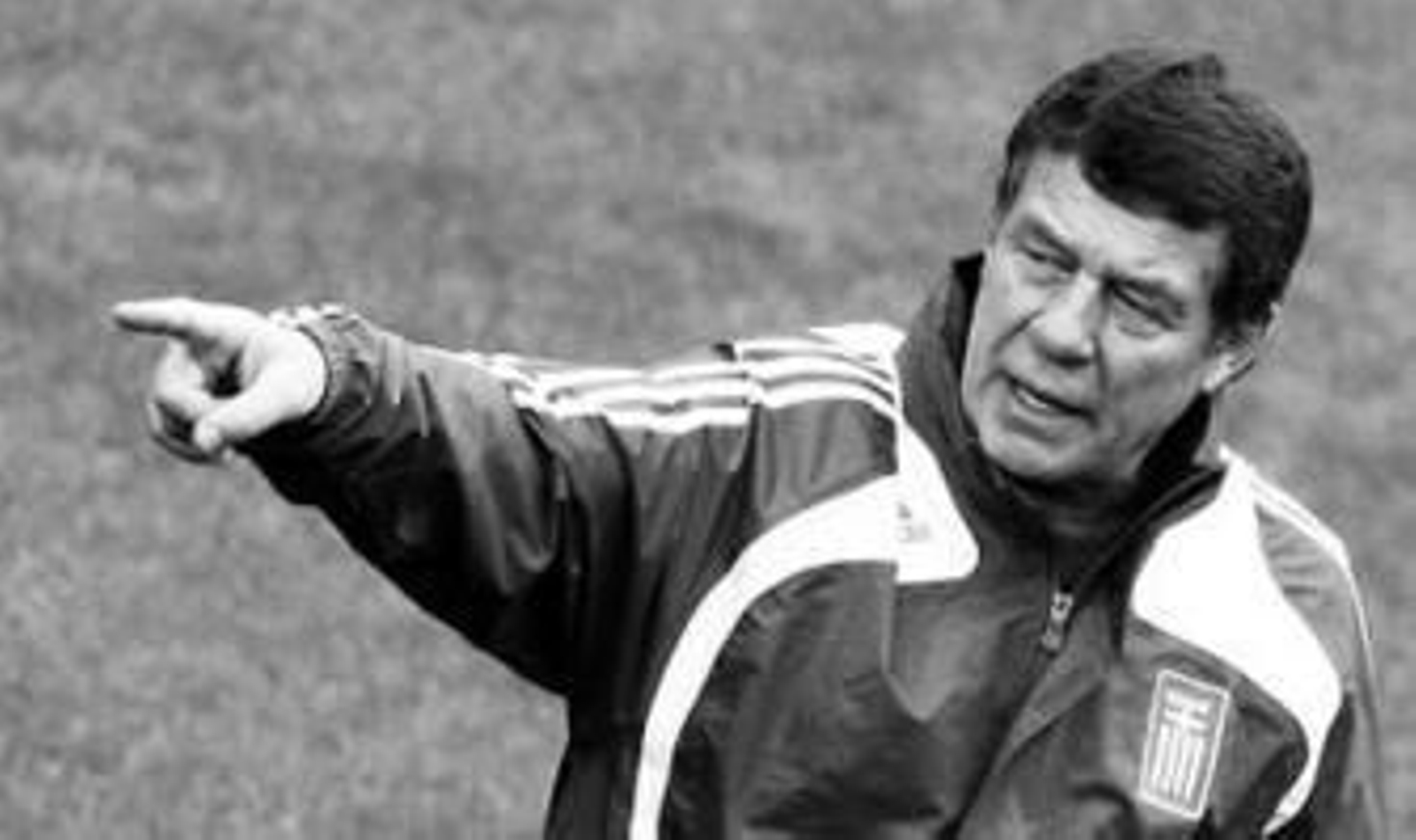 Luis Aragonés se cubre la cabeza por la lluvia.