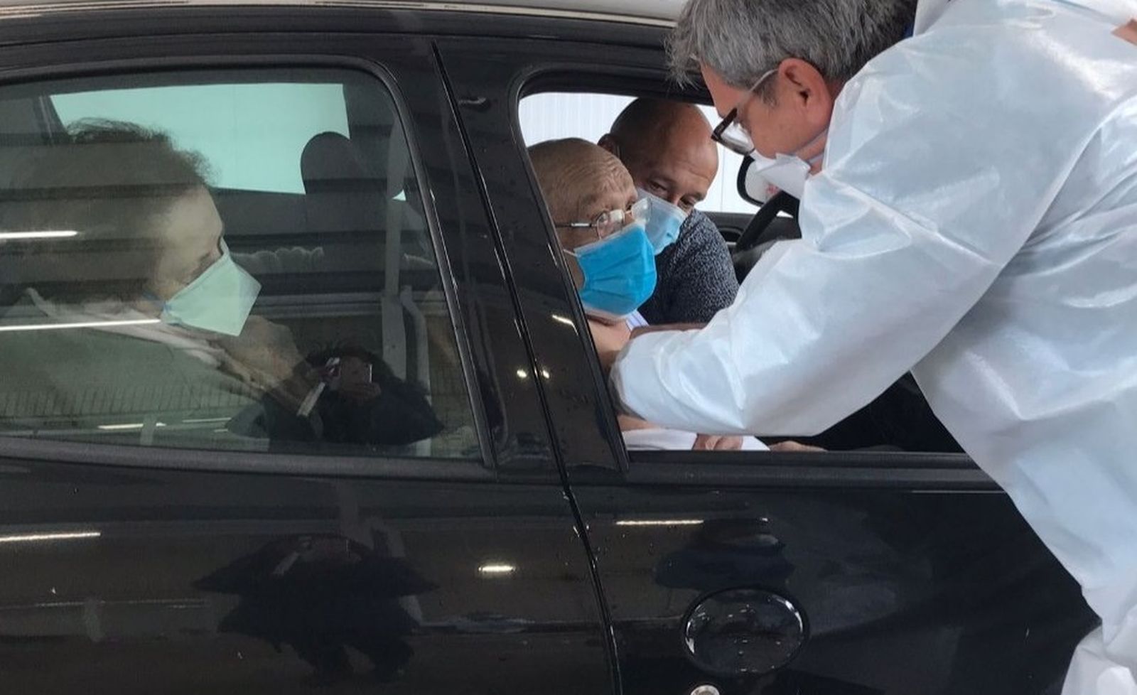 Un enfermero vacuna a un anciano en su coche en el Distrito Sanitario Sevilla.