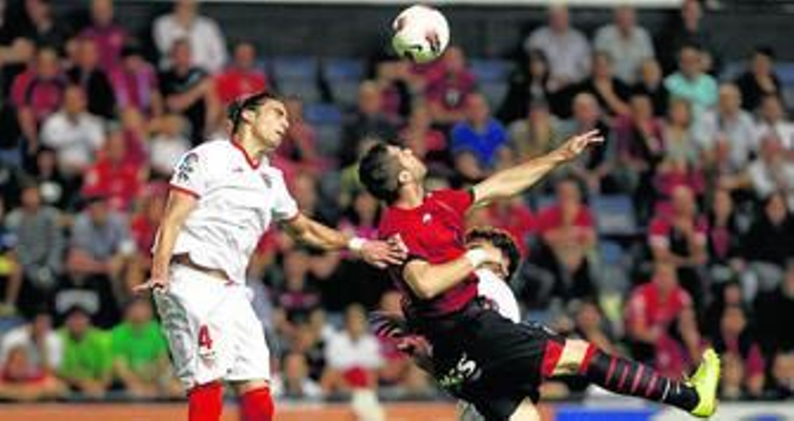 Cáceres se emplea con mucha seguridad en un balón aéreo que también pretende ganar, con arabesco incluido, el atacante osasunista Kike Sola.