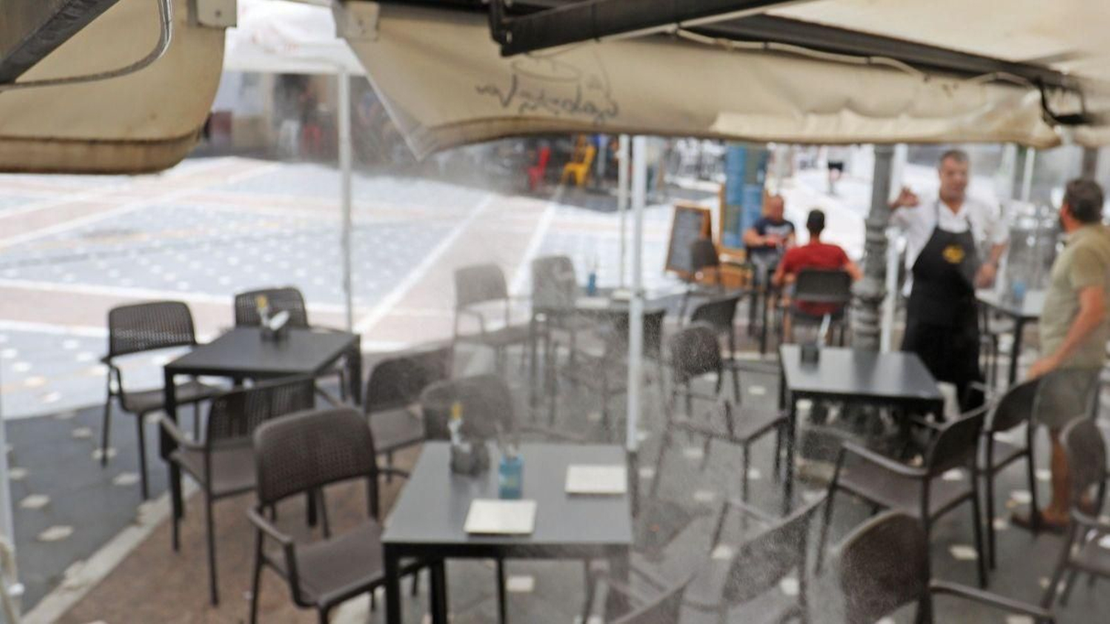 Terraza de un bar del centro, refrescada por nebulizadores con agua.