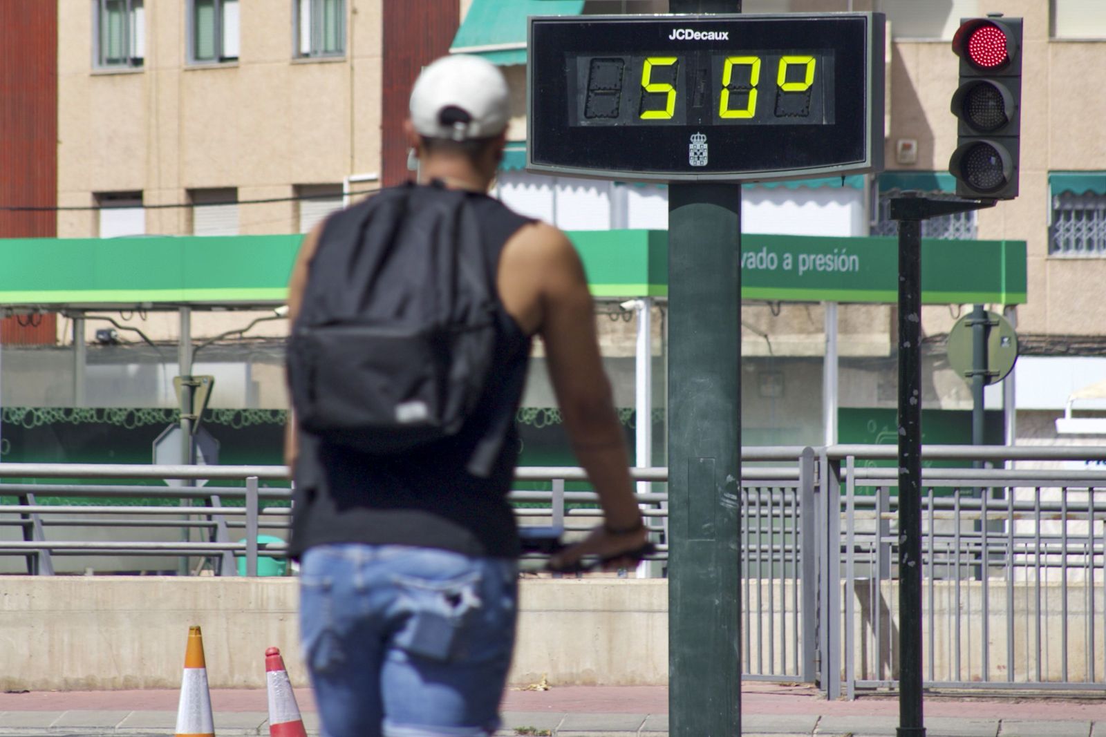 Un hombre pasa ante un termómetro que marca 50 grados.