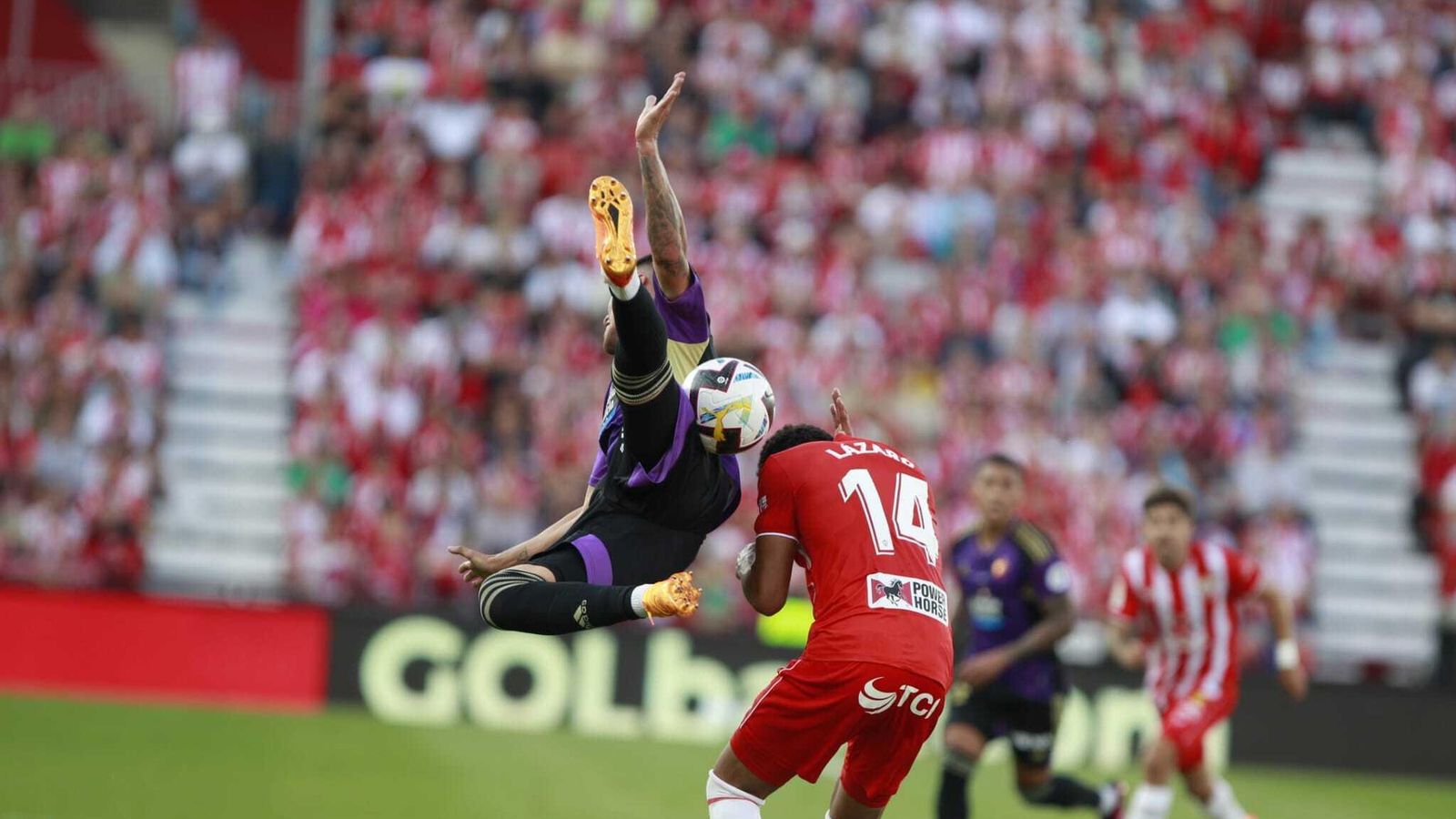 Lázaro se protege de una entrada acrobática de un rival