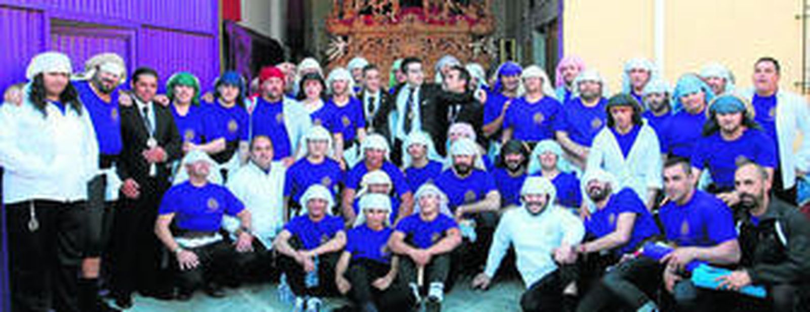 Miembros de la cuadrilla de costaleros de la hermandad, a los pies del paso del Señor.