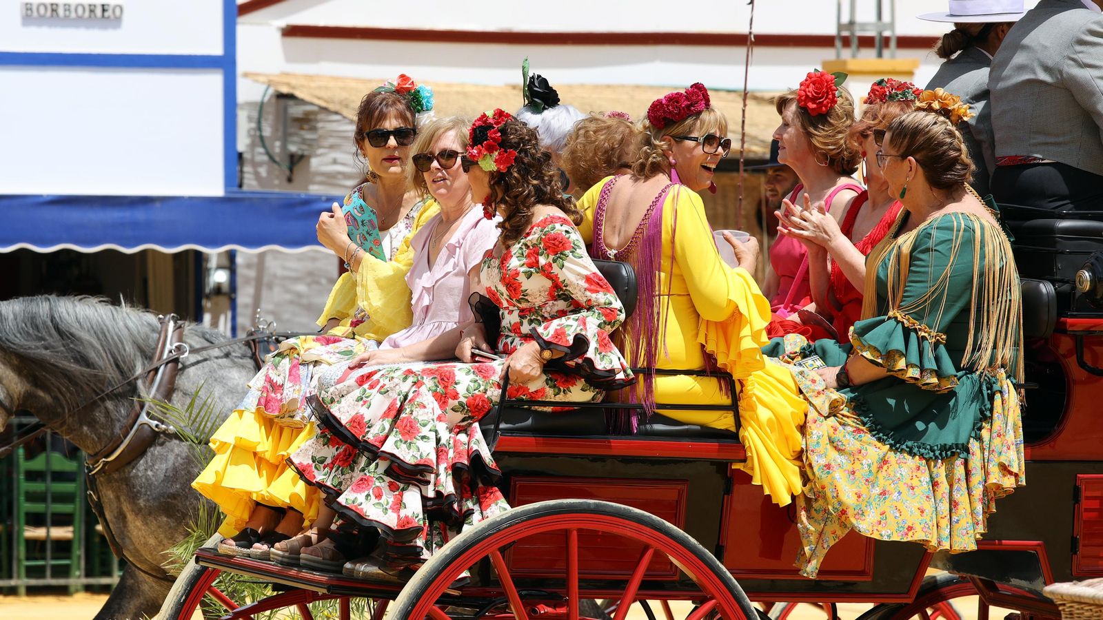 Un grupo de mujeres en un enganche por el paseo de caballistas
