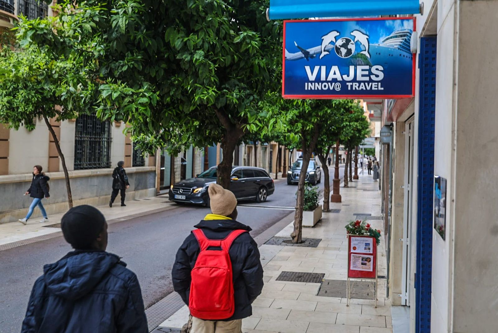 Dos personas pasan junto a una agencia de viajes en la capital.