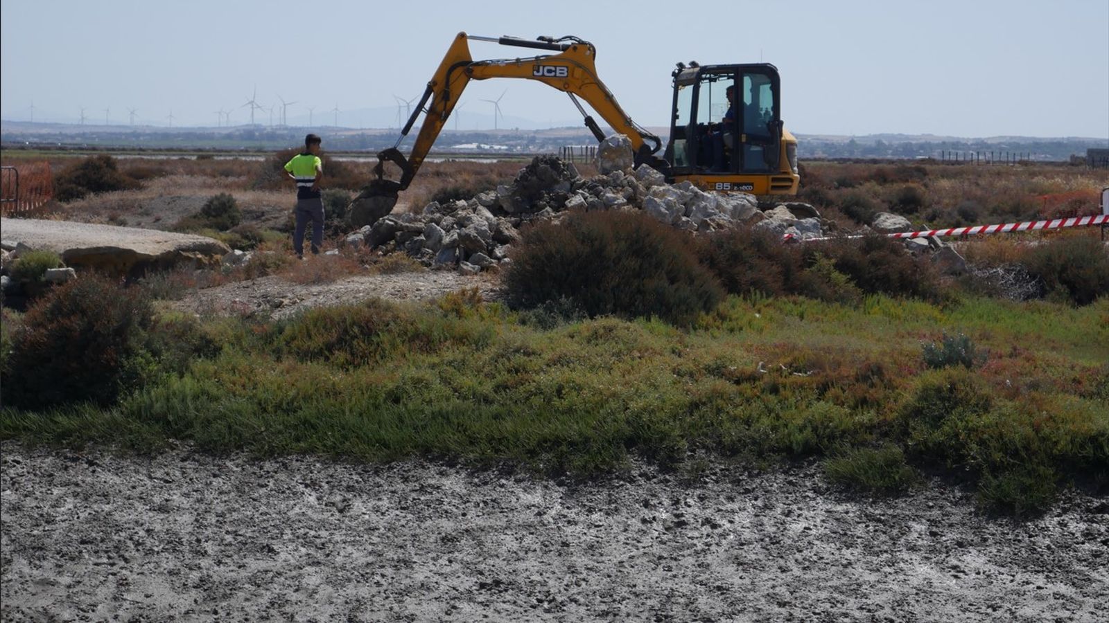 La excavadora retirando escombros en las proximidades de las compuertas.