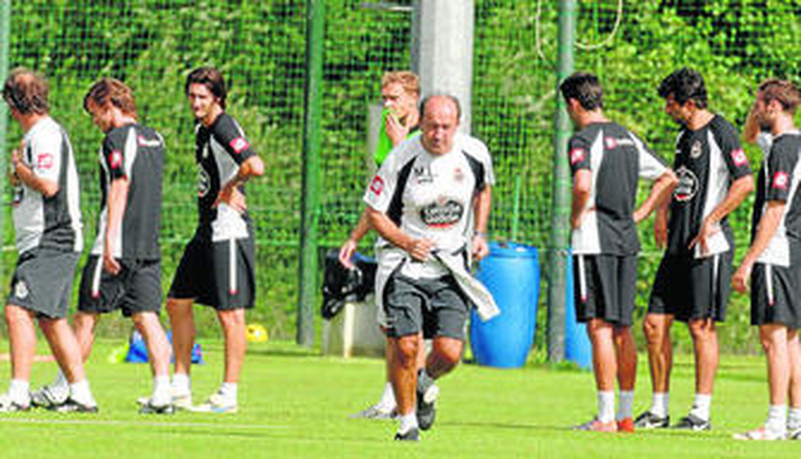 Lotina corre rodeado de sus jugadores durante un entrenamiento de esta semana.