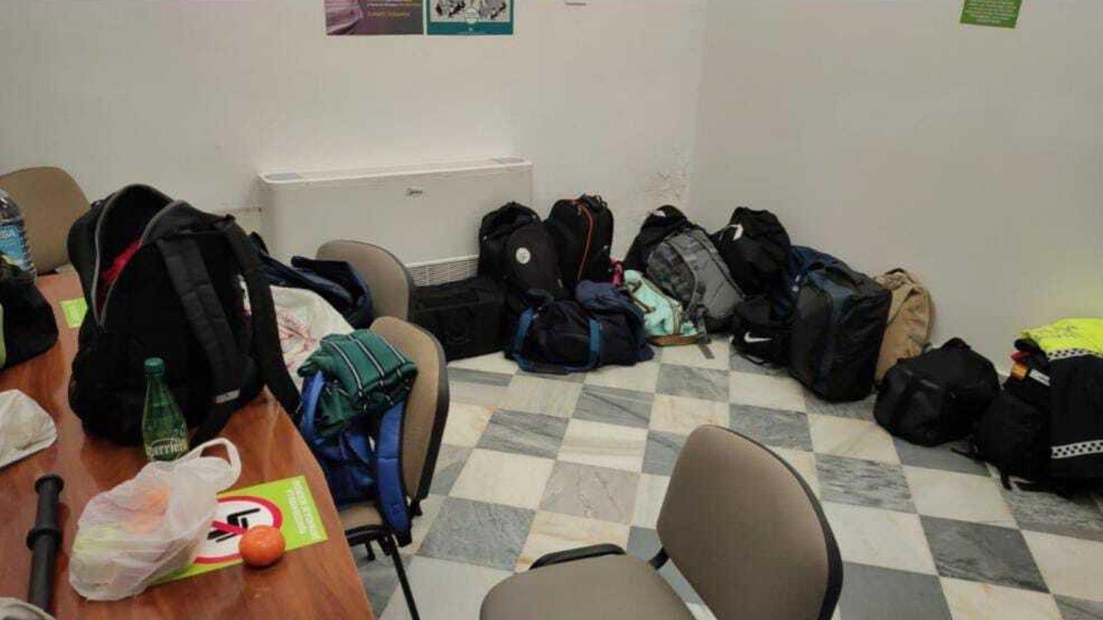 Mochilas y pertenencias tiradas por el suelo.