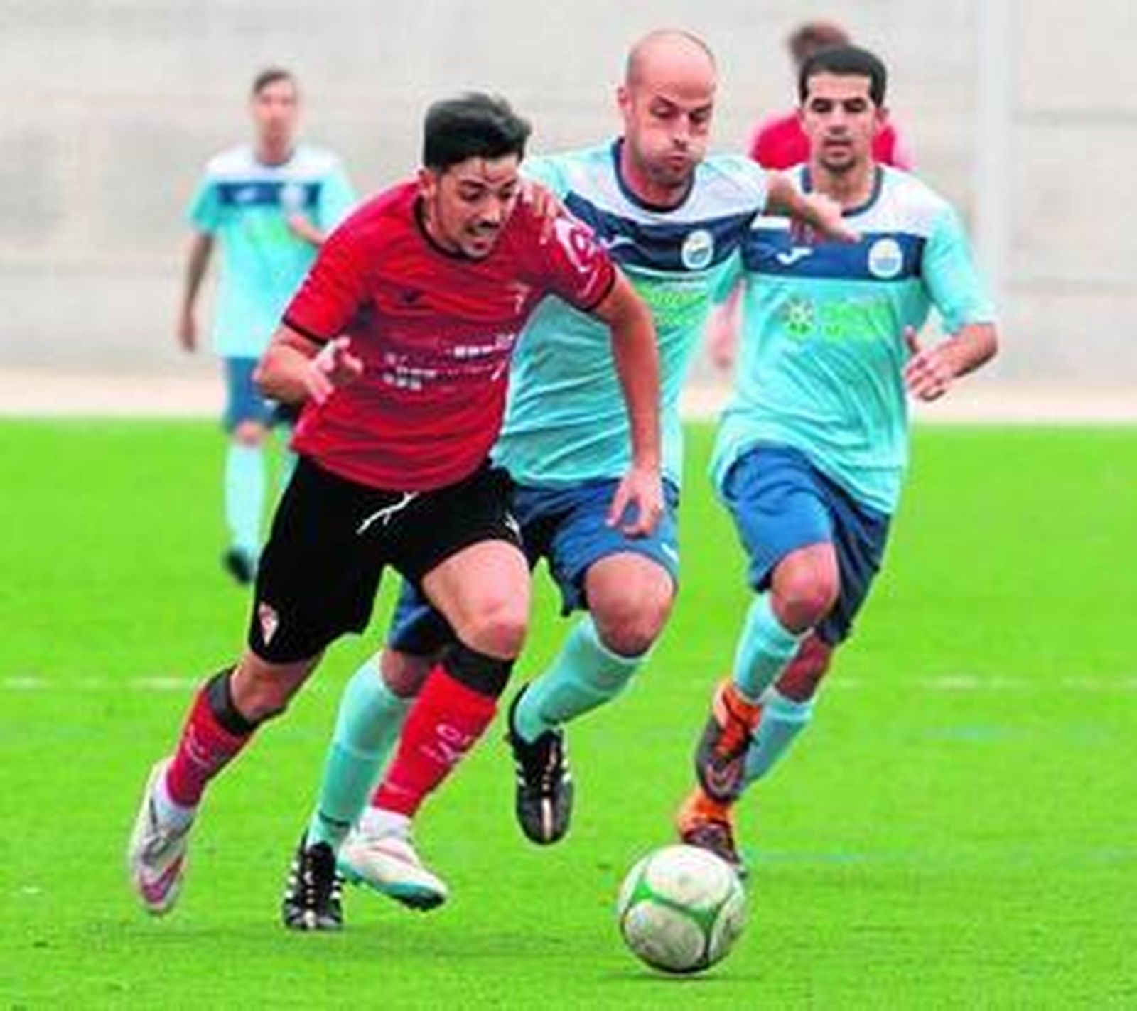 Un jugador del Egabrense escapa de la presión de dos jugadores del Alcolea.