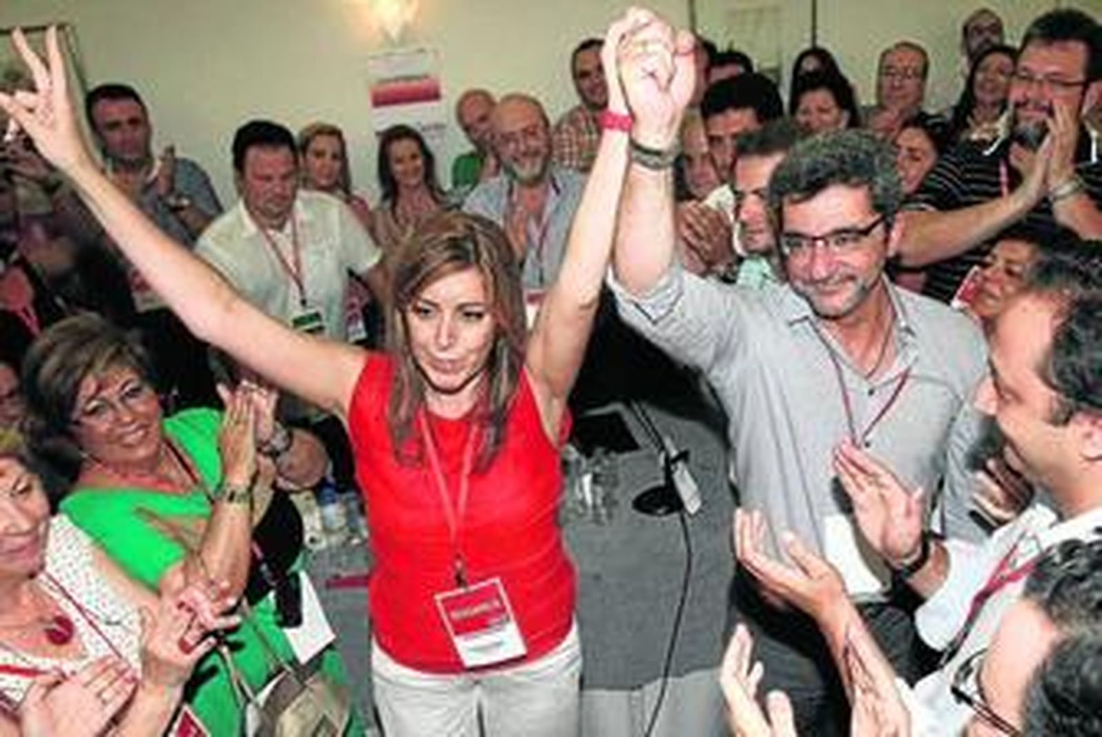 Susana Díaz levanta los brazos, tras recibir la felicitación de Antonio Gutiérrez Limones a pie de urna.