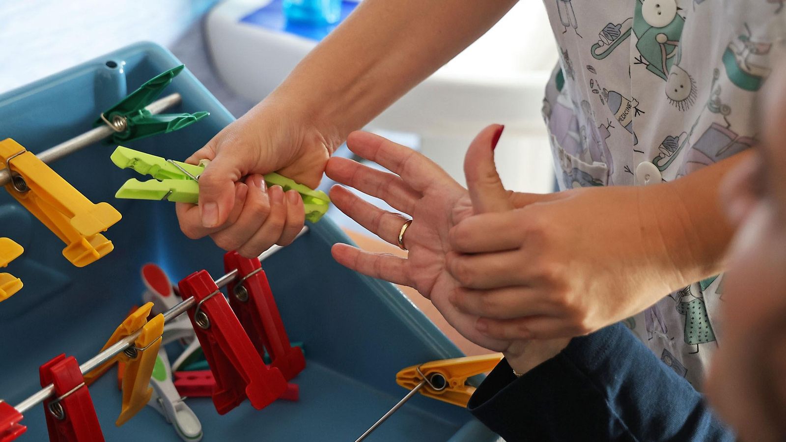 Las manos de Leo trabajan el agarre con pinzas de tender la ropa.