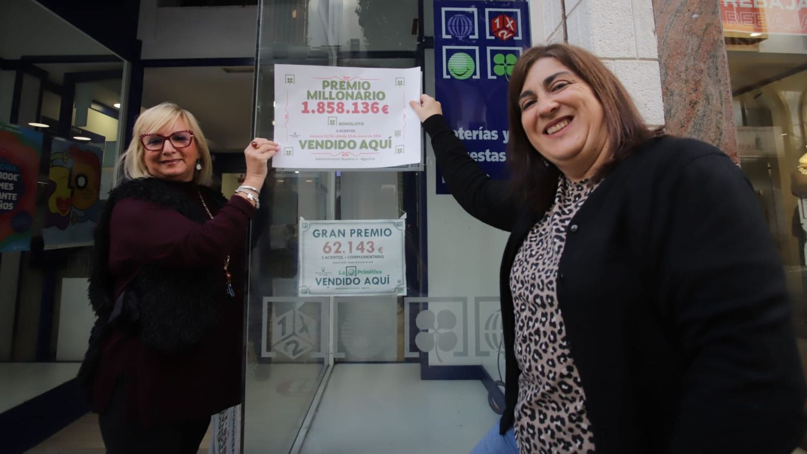 Rocío y Pepi cuelgan a primera hora de la mañana el cartel del premio millonario en el escaparate de la Administración nº 5, en la calle Convento.