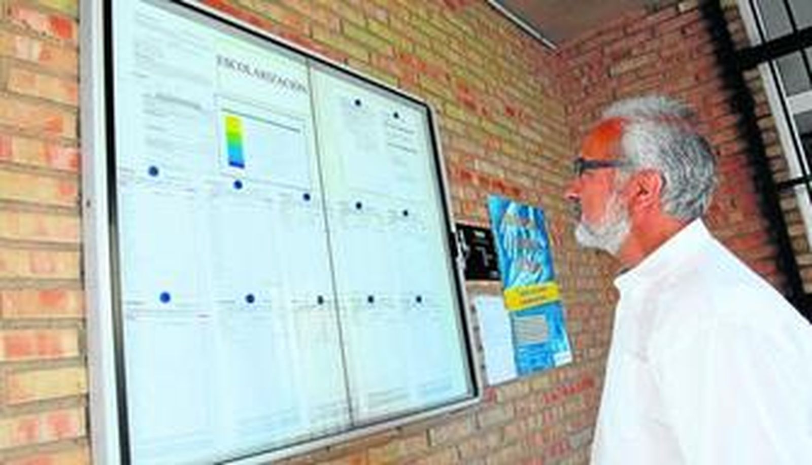 Un hombre consulta el listado de los solicitantes con sus puntos correspondientes en el colegio García Lorca.