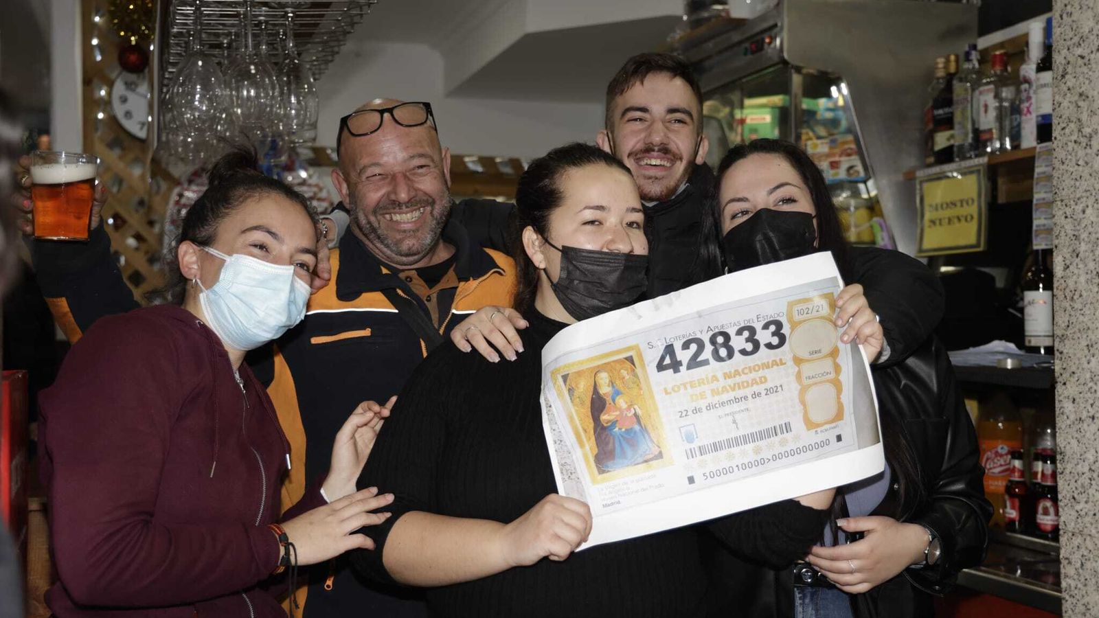 Trabajadores y clientes del bar La Bodega posan con el segundo premio.