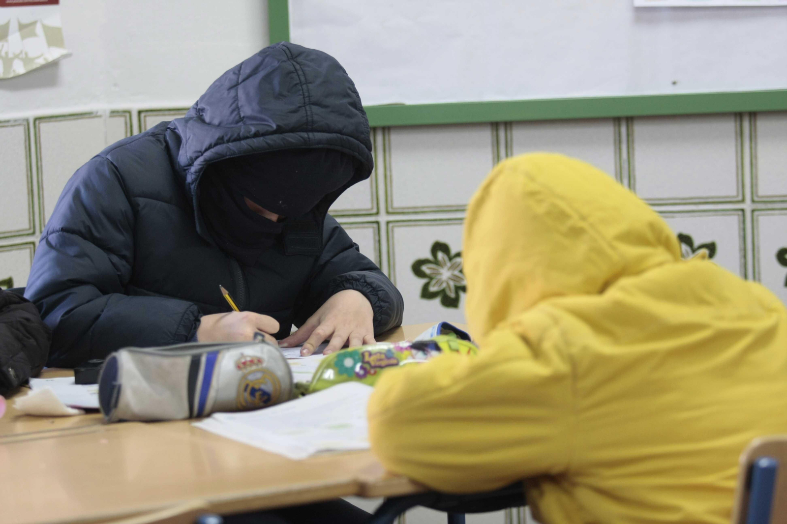 Alumnos con abrigos en clase por falta de calefacción.
