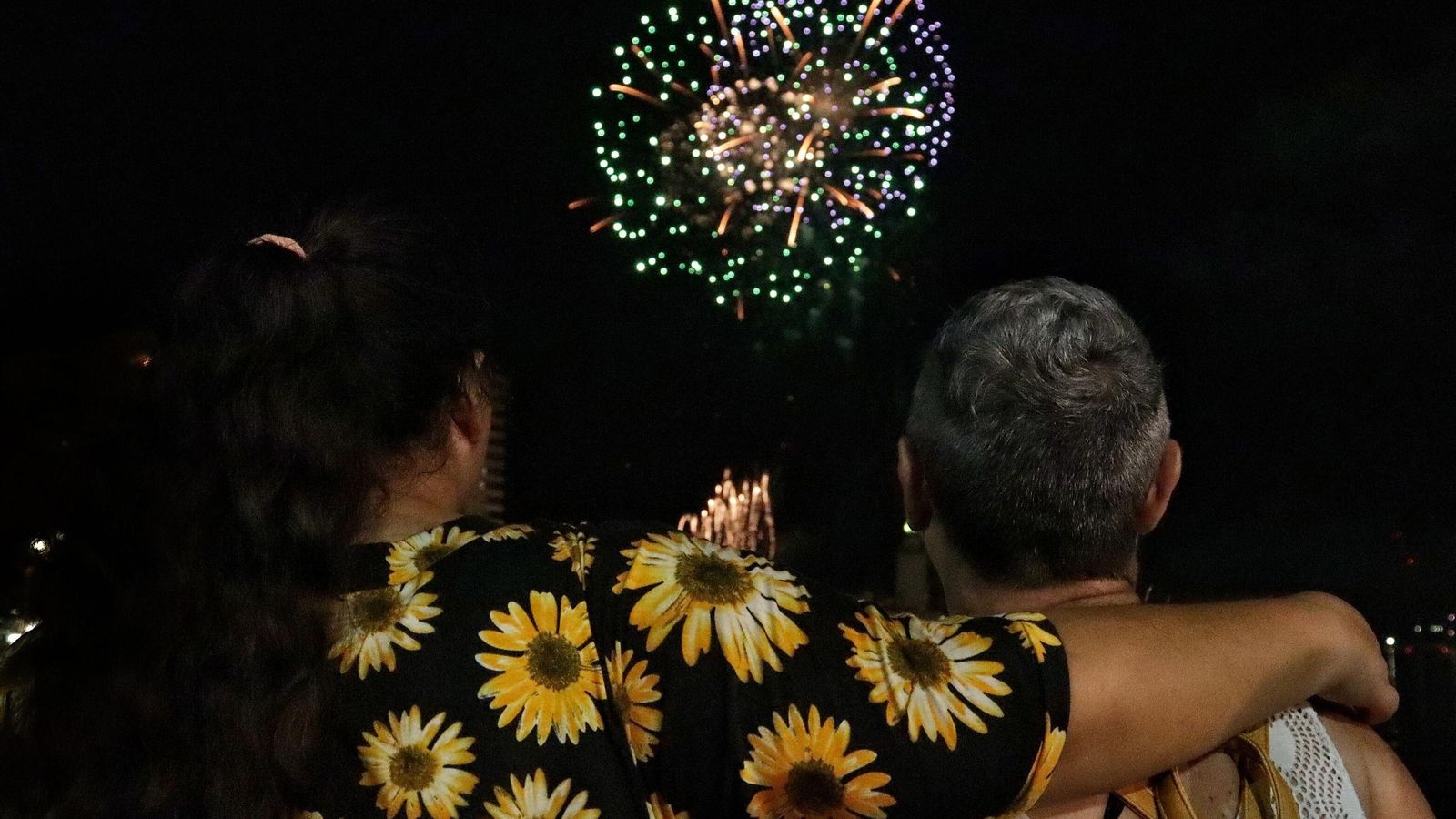 Una pareja observa los fuegos artificiales desde el Muelle Uno.