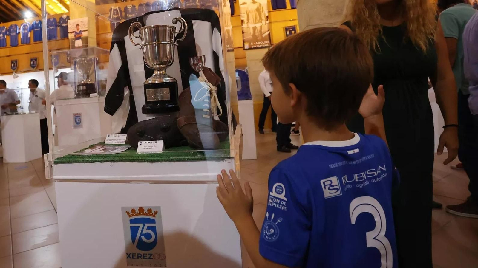 Un pequeño seguidor del Xerez CD contempla uno de los trofeos históricos en la exposición del 75 Aniversario.