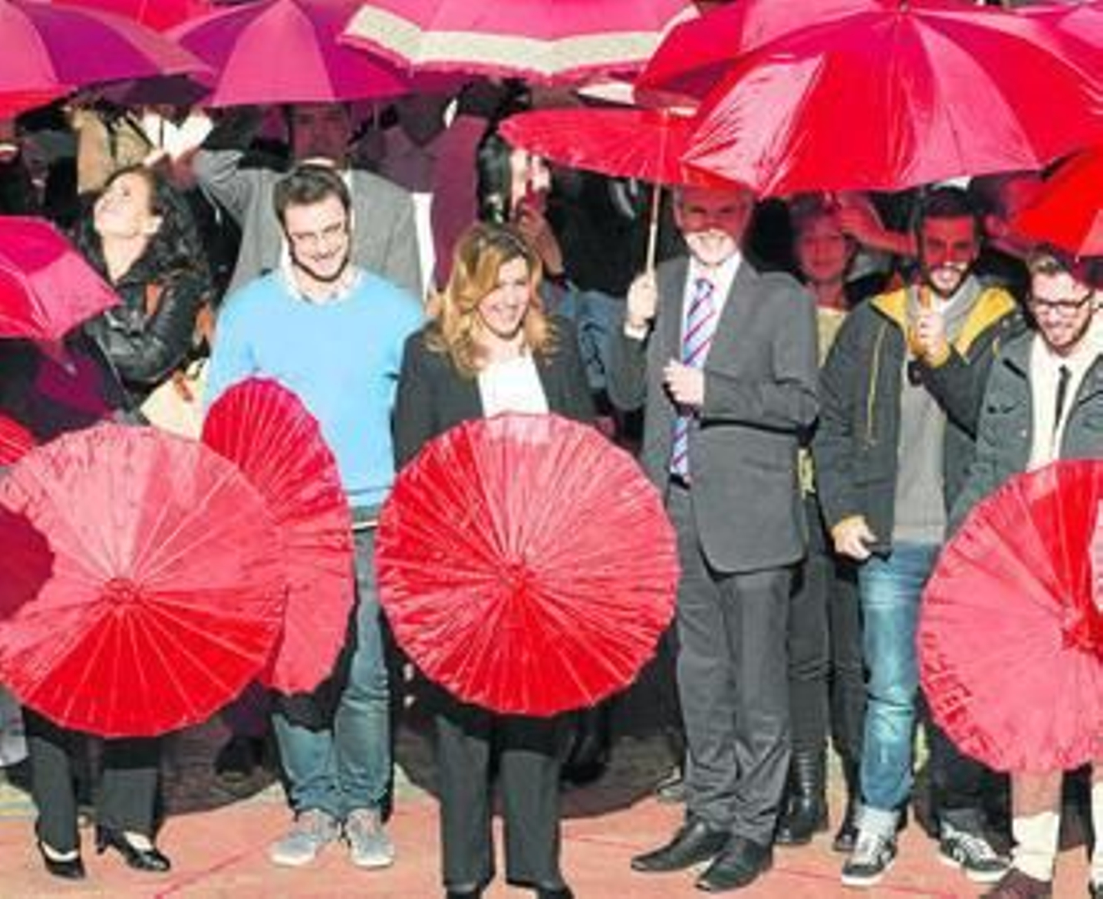 Díaz y estudiantes forman ayer un lazo rojo con paraguas en la celebración del día mundial de la lucha contra el sida.