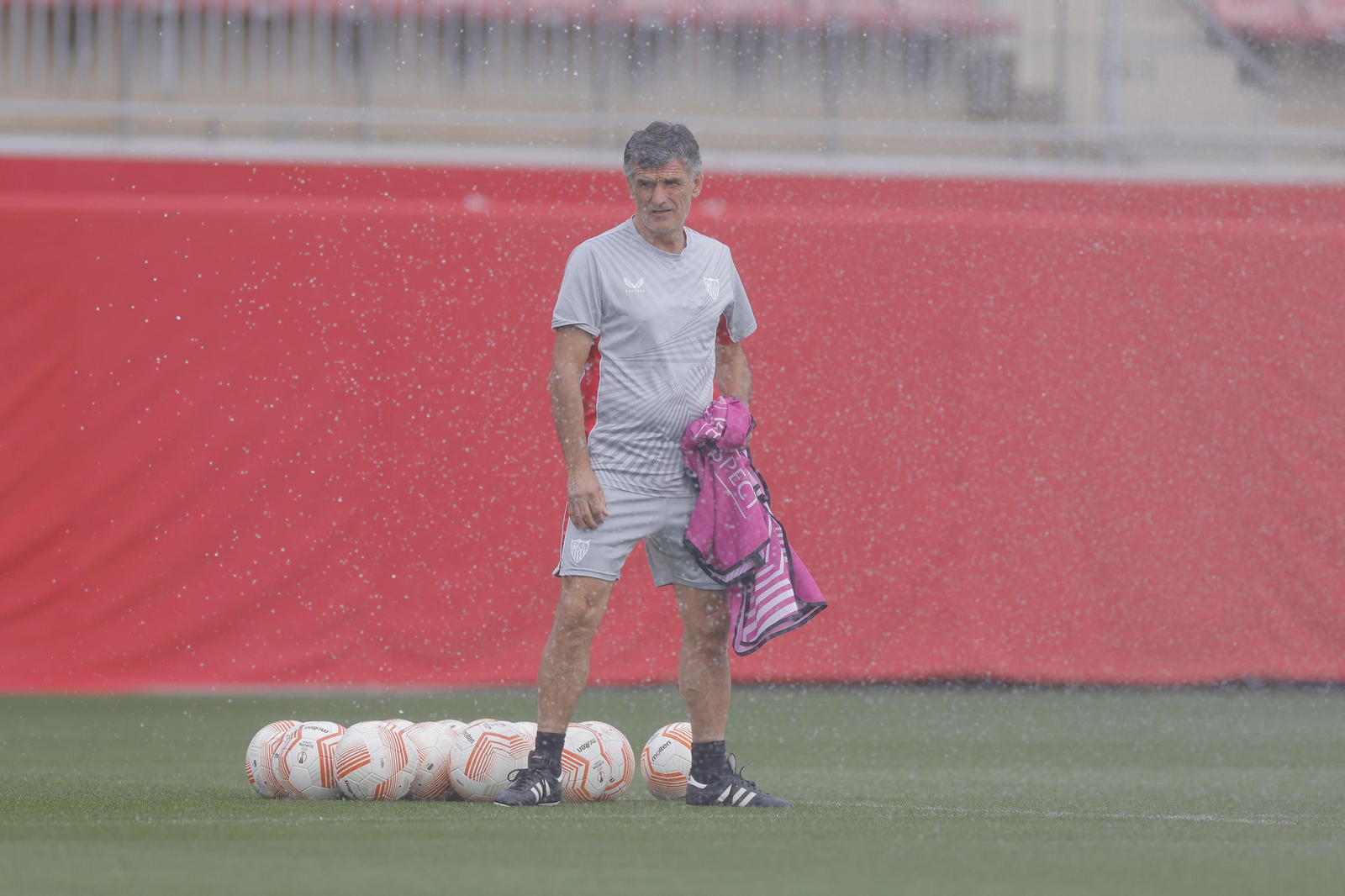 Mendilibar, con un peto, prepara el entrenamiento tras una cortina de agua del riego.