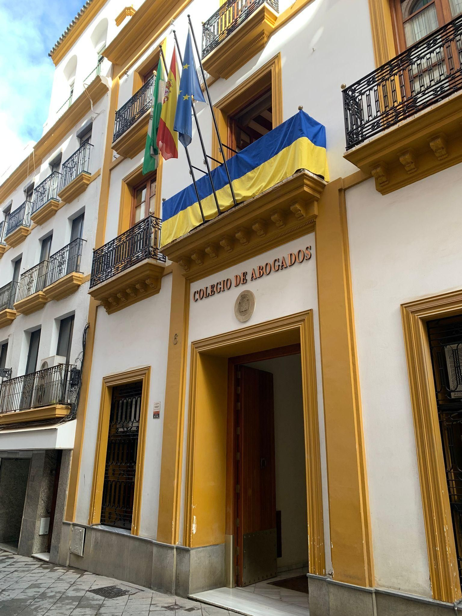 La fachada del Colegio de Abogados de Sevilla con una bandera de Ucrania