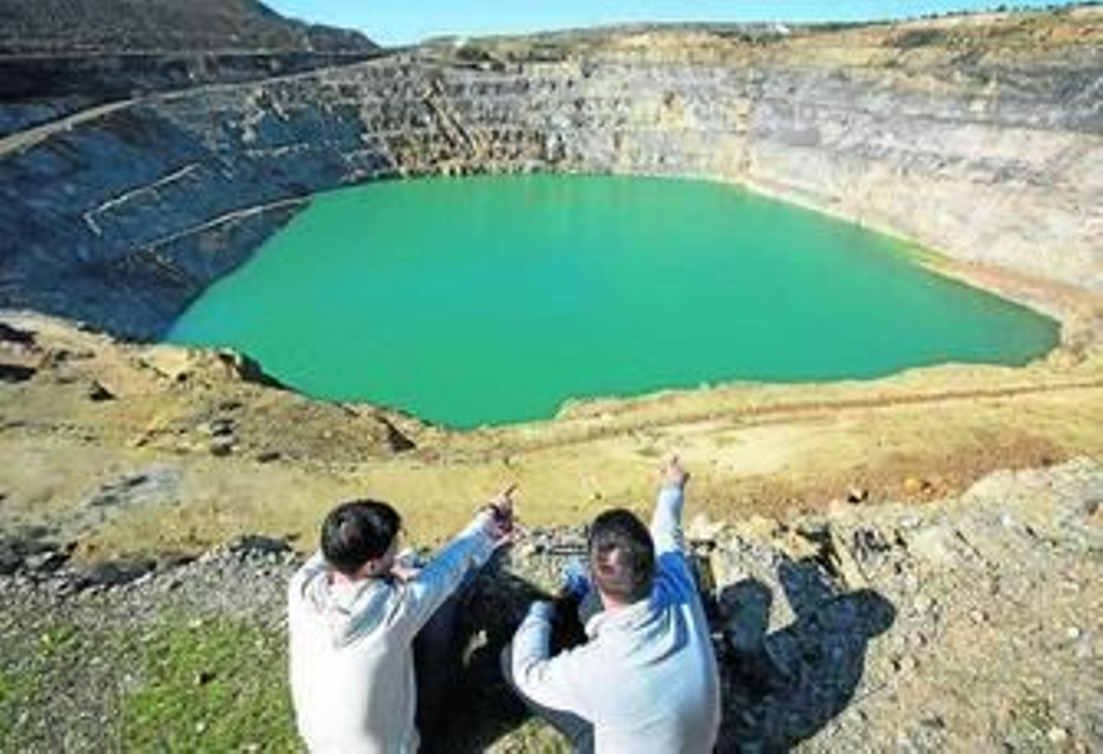 Dos jóvenes señalan la corta de Los Frailes desde si mirador.