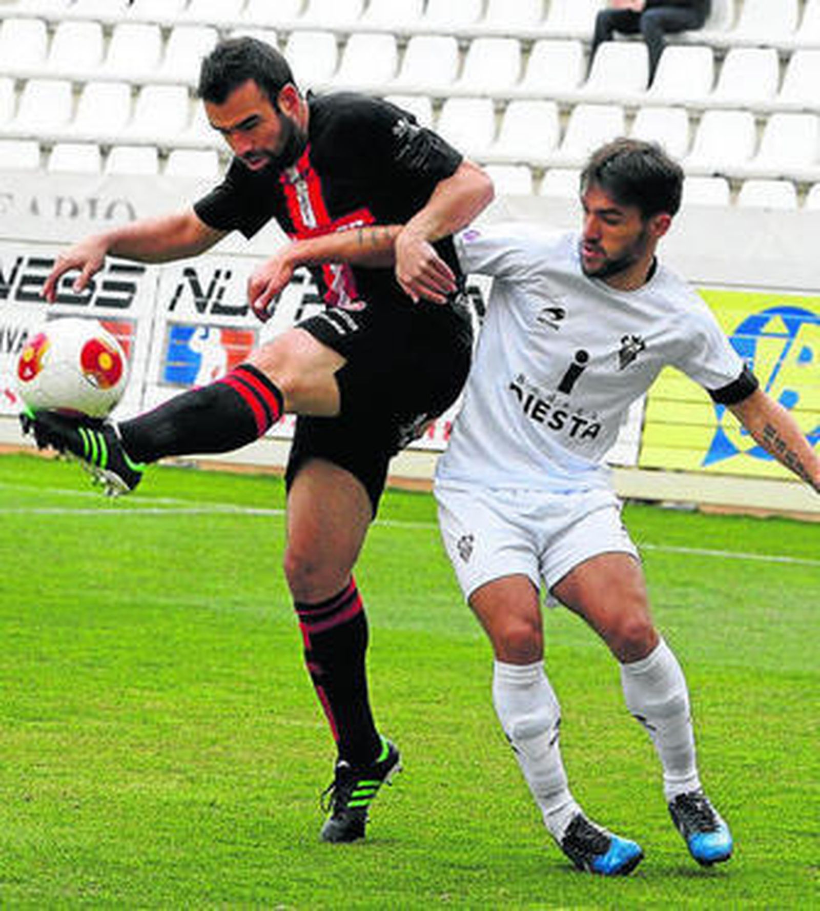 Víctor González (i) pelea en defensa ante la presión de un rival.