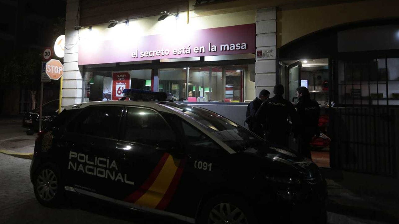 Un patrullero y varios policías nacionales trabajan en la puerta del restaurante.