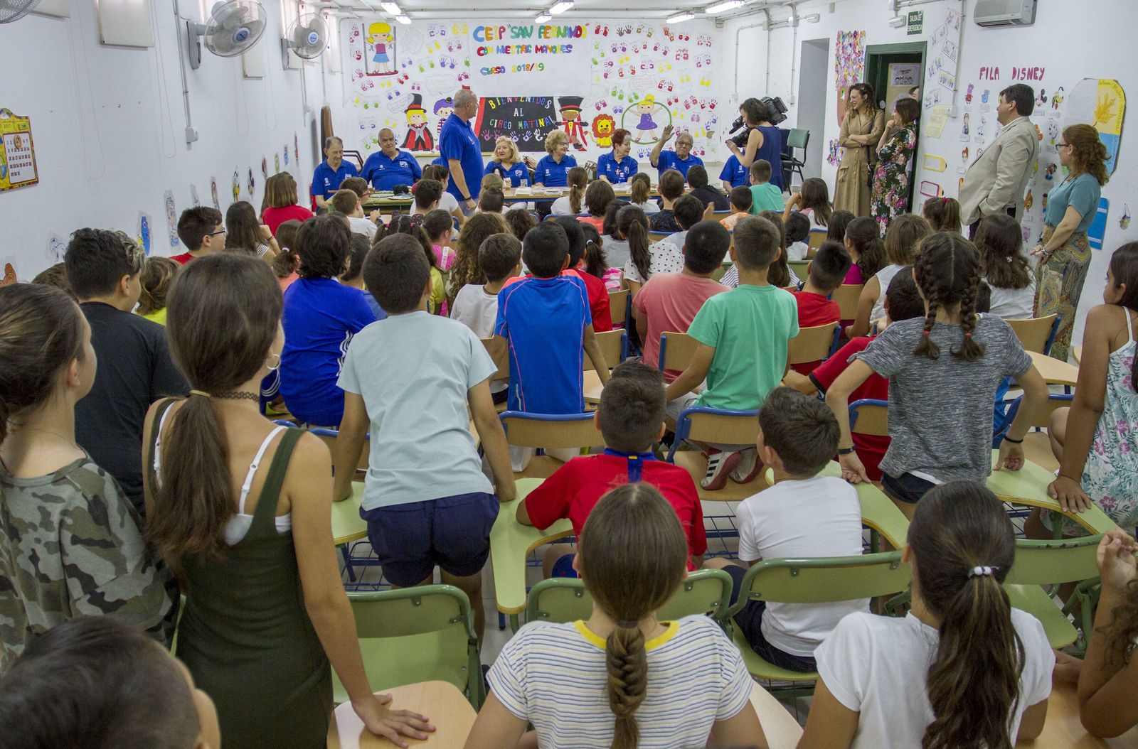 Los escolares, muy activos durante toda la sesión, atienden a los mayores participantes en el programa, a su paso por el colegio San Fernando hace unos días.