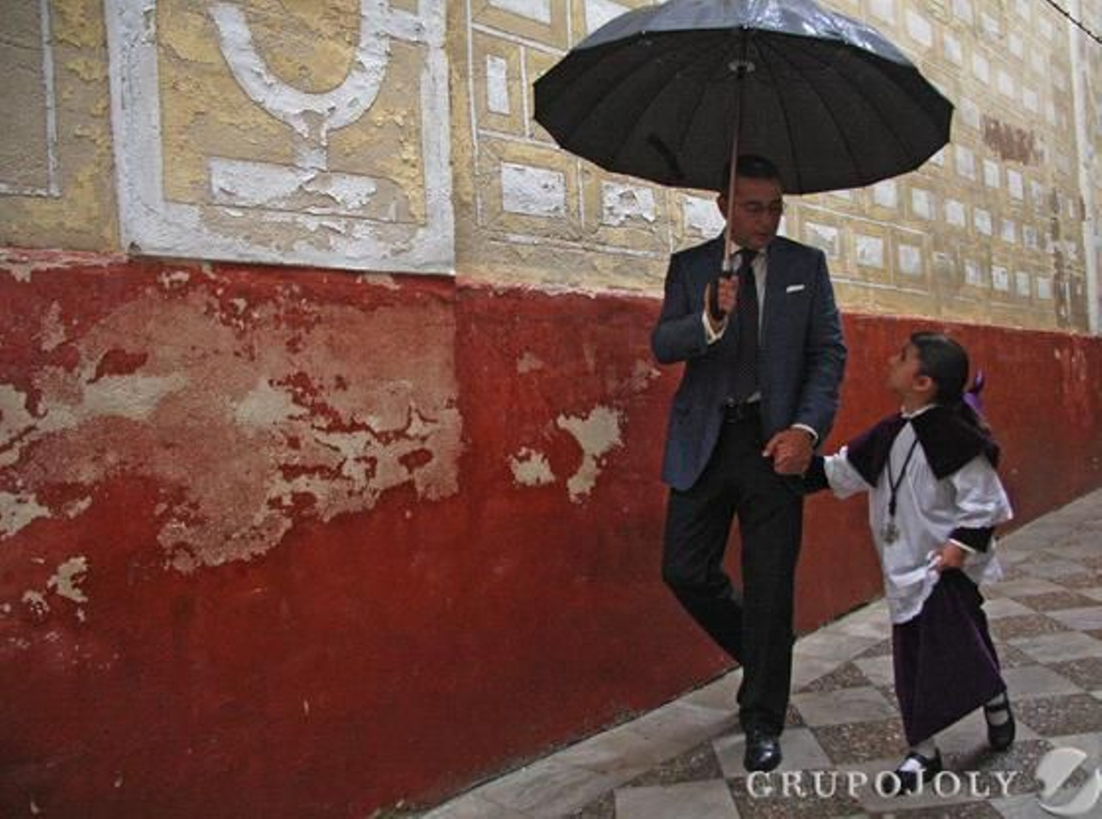 La lluvia cayó con fuerza a la hora de salida de la Hermandad de Santa Cruz que obligó a los hermanos a llegar a la Parroquia con paraguas.  Foto: B.Vargas