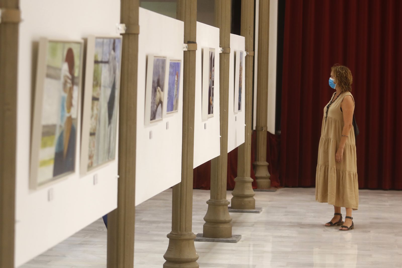 Una mujer observa una exposición en el Teatro Cómico.