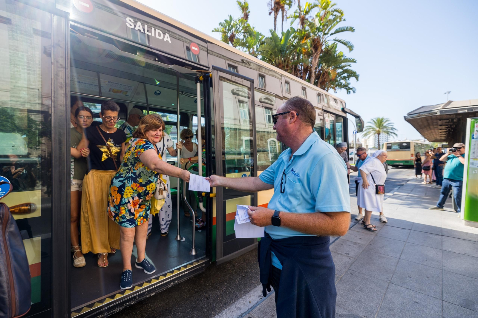 Un trabajador de la empresa de autobuses Cádiz y San Fernando reparte hojillas informativas sobre la huelga en la parada junto a la plaza de España.