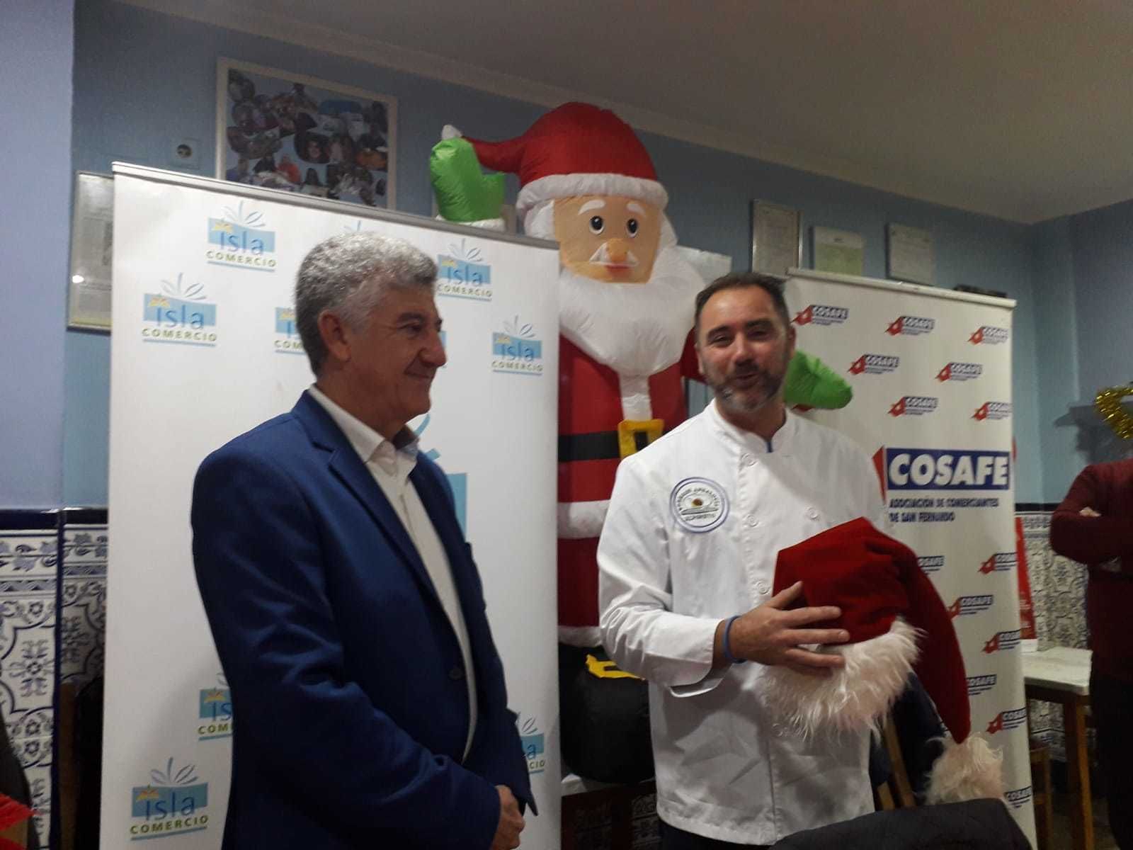 Alfonso, del Bodegón Andalucía, junto a Manuel Luna tras recibir el testigo: el gorro de Papá Noel