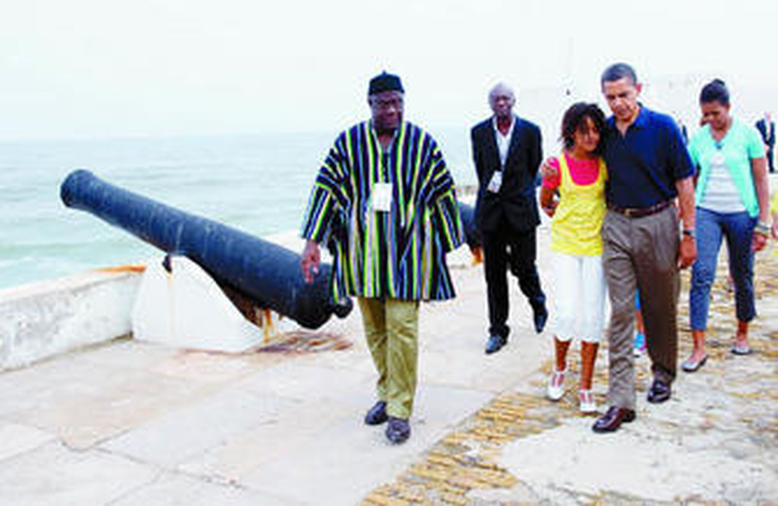 Obama abraza a su hija mayor, Malia, seguido de su mujer durante su visita al centro de esclavos de Cape Coast, en Ghana.