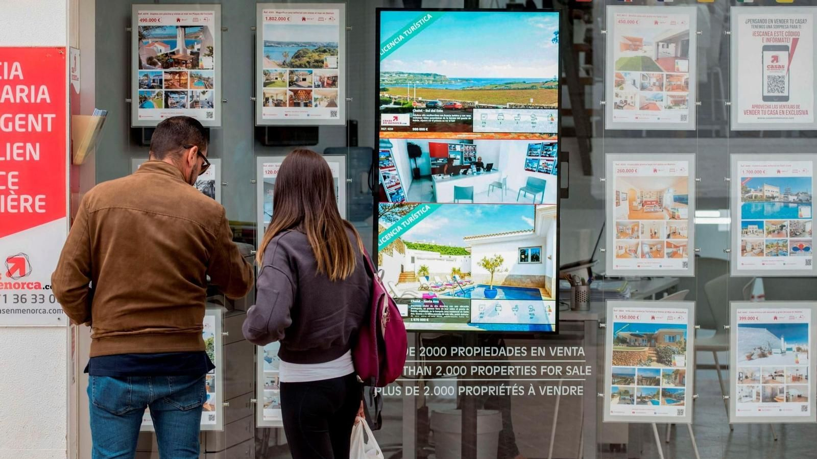 Una pareja mirando los anuncios de una inmobiliaria