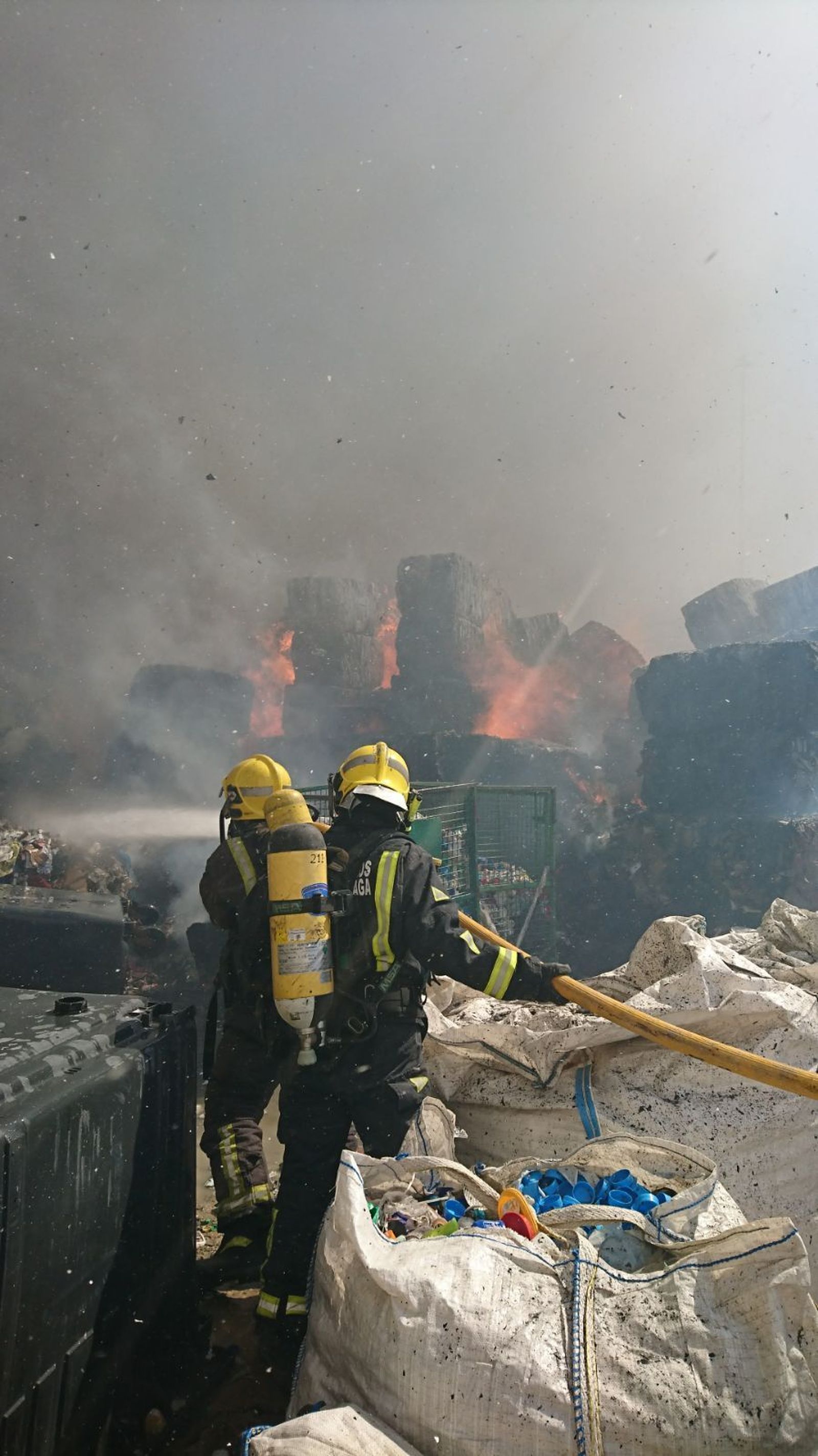 Las llamas consumen los residuos de cartones y papeles de la planta.
