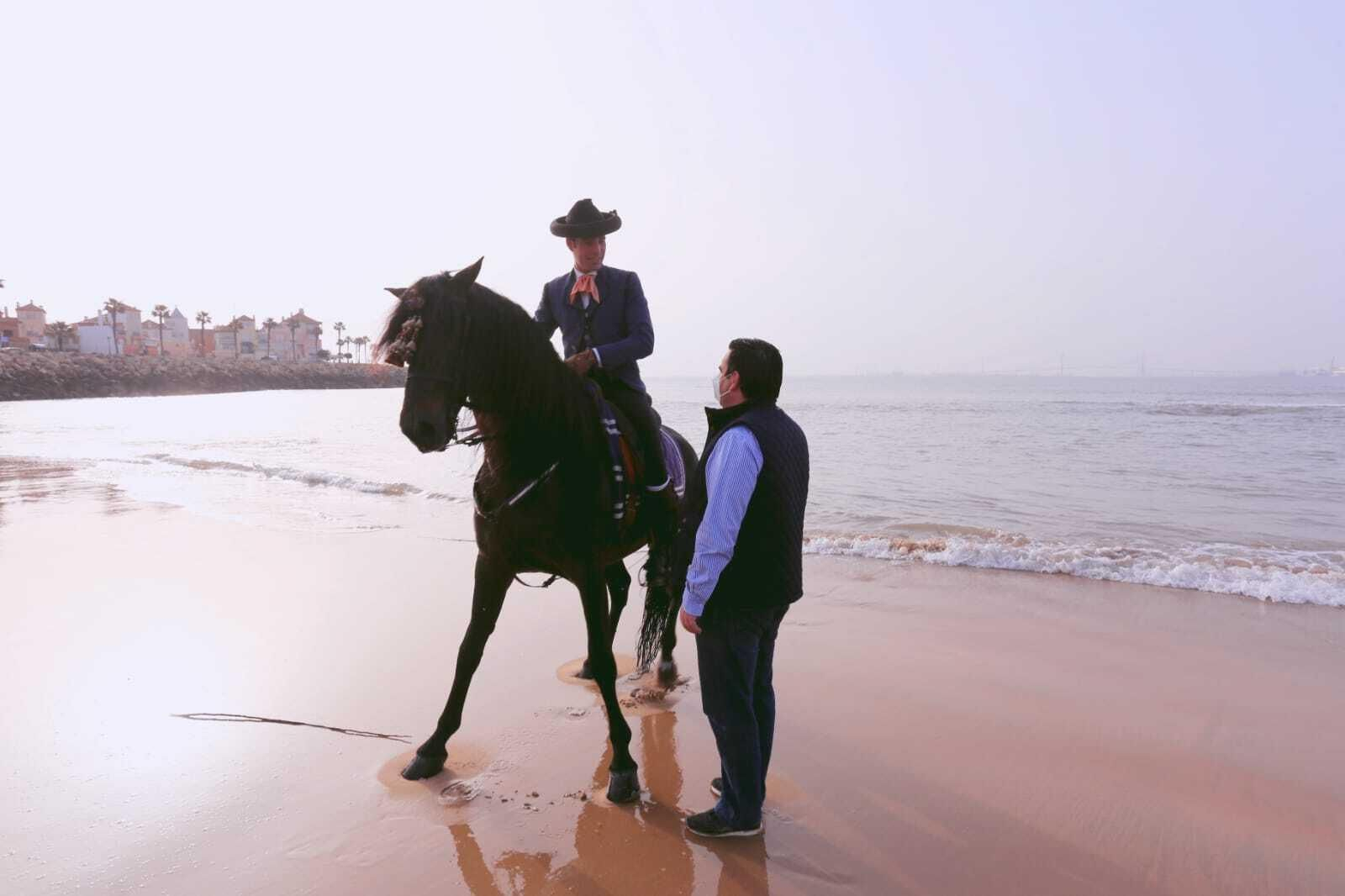 El concejal de Turismo intercambia impresiones con uno de los jinetes de la yeguada, con Puerto Sherry al fondo.