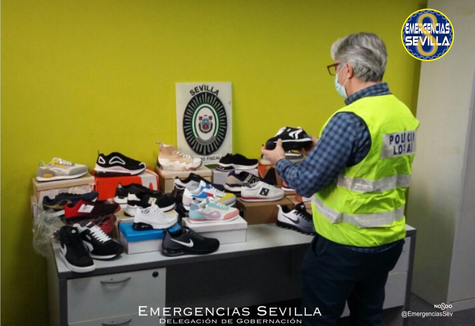 Un policía local de Sevilla examina las zapatillas intervenidas.