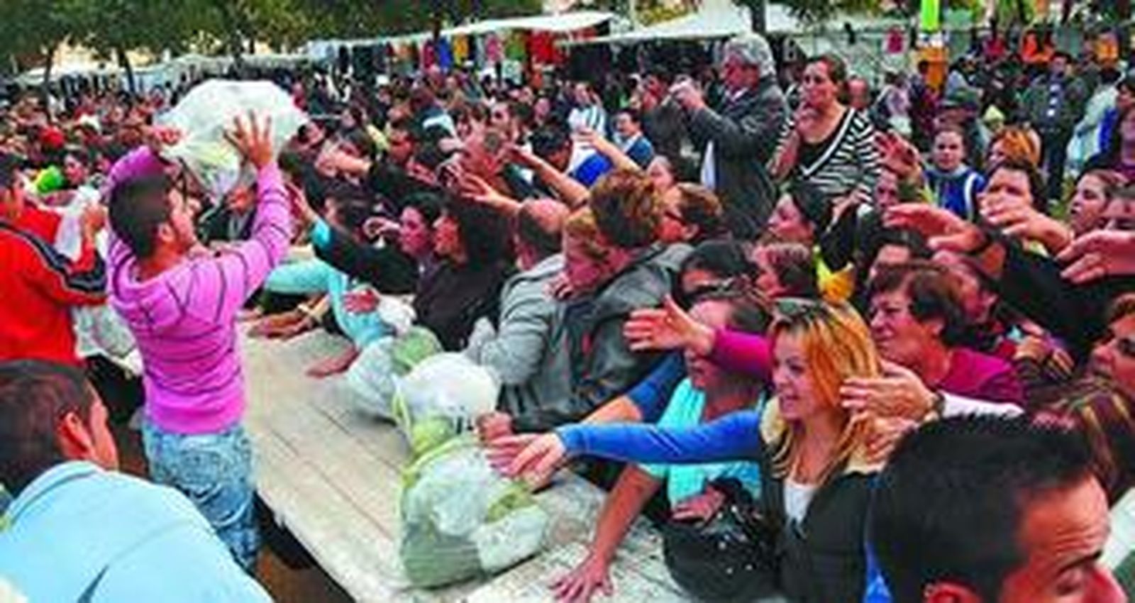 Centenares de personas se concentraron junto al mercadillo ambulante de La Dehesilla para conseguir gratis bolsas de hortalizas.