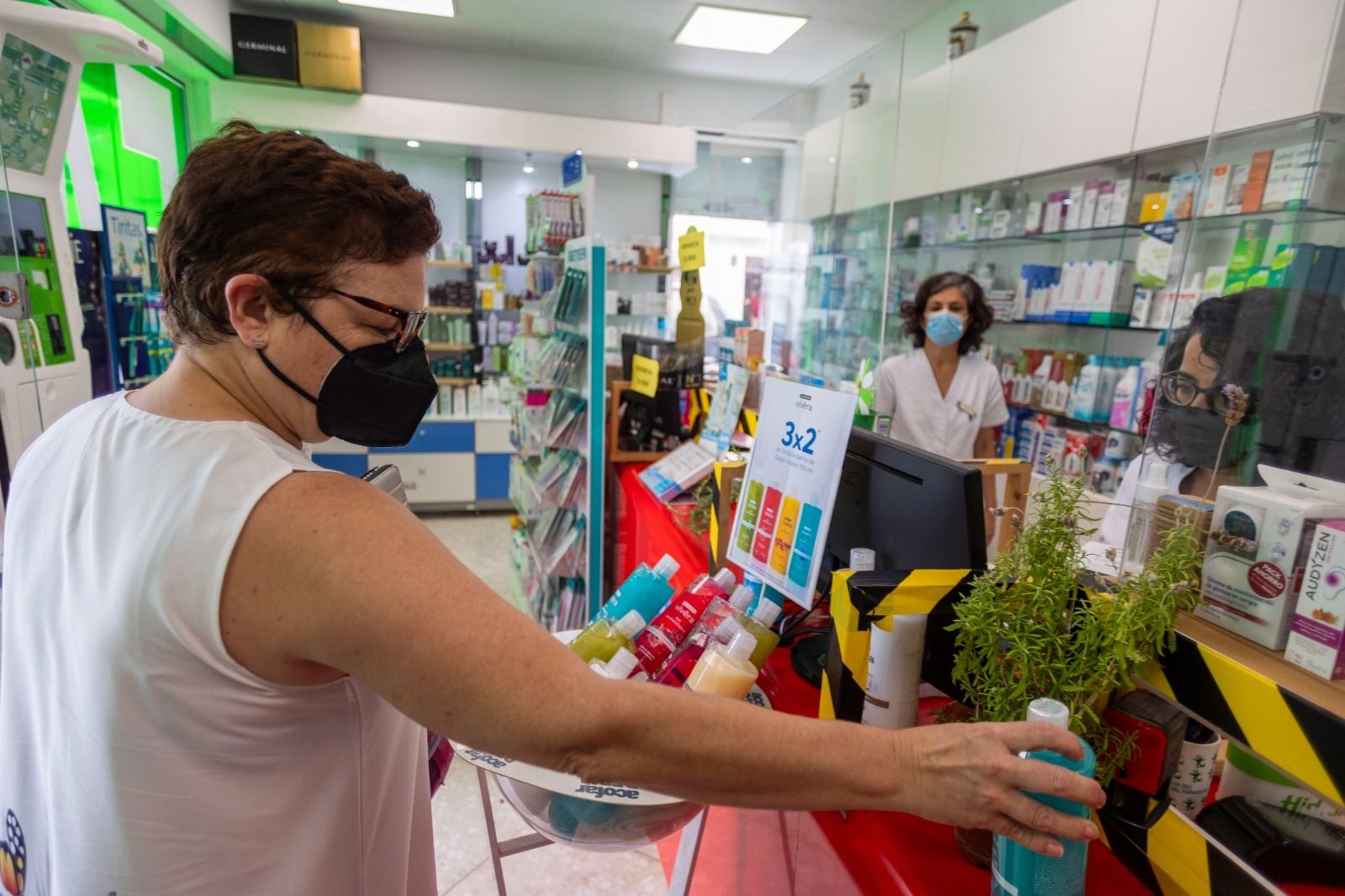 Una mujer, con mascarilla, en el interior de una farmacia de Cádiz