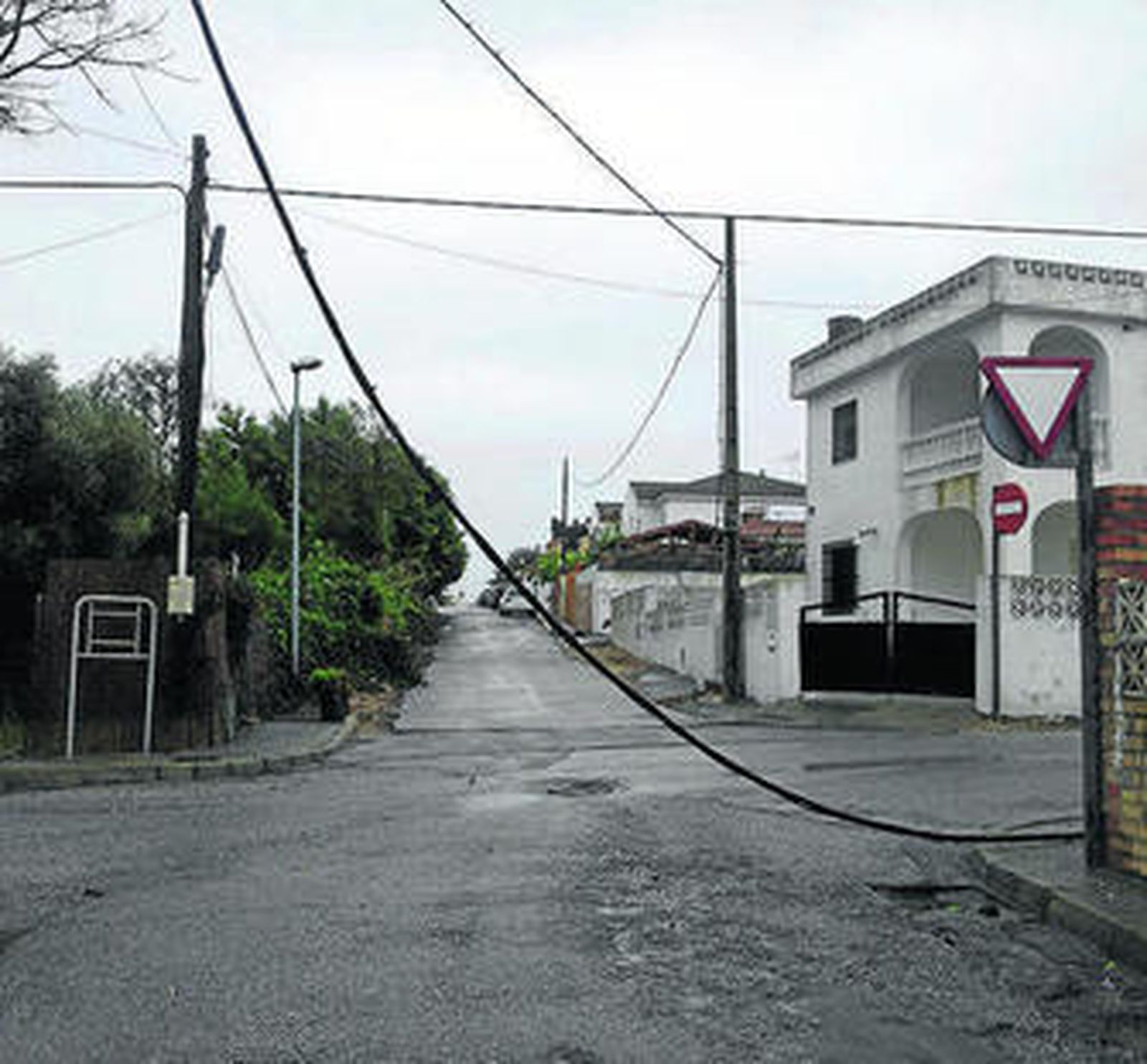 El cable desplomado de forma peligrosa sobre la calle Fresa, en Fuentebravía.