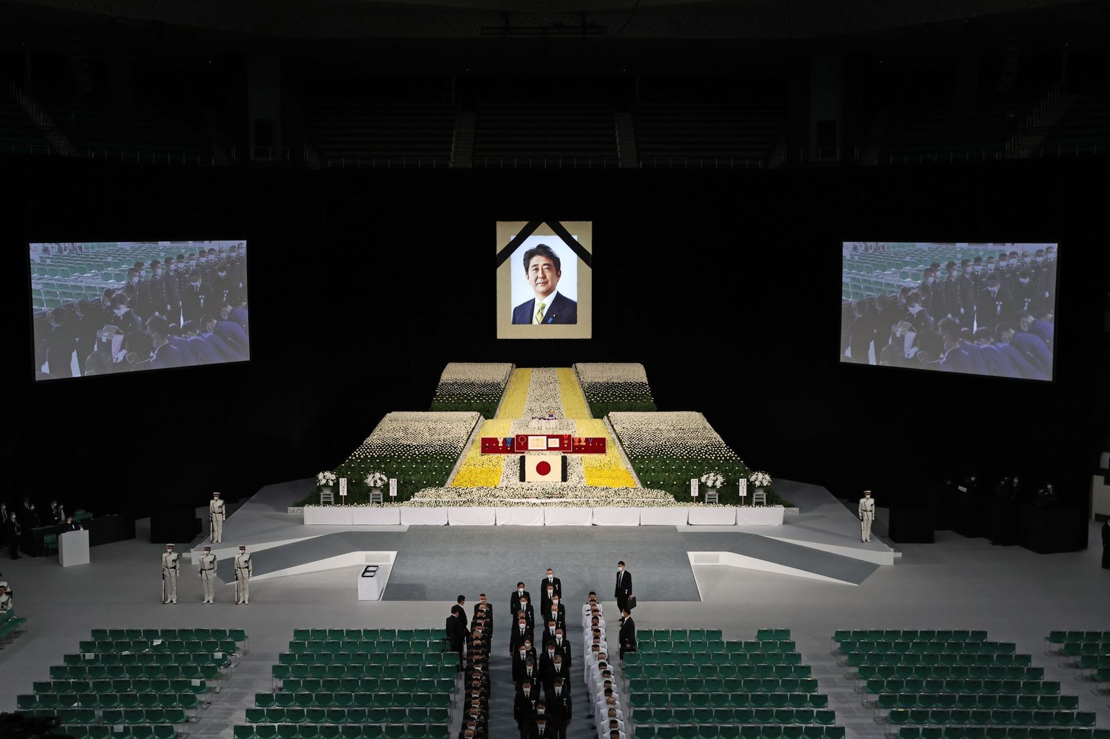 La viuda del ex primer ministro japonés Shinzo Abe (en las pantallas) porta sus cenizas en el funeral de Estado.
