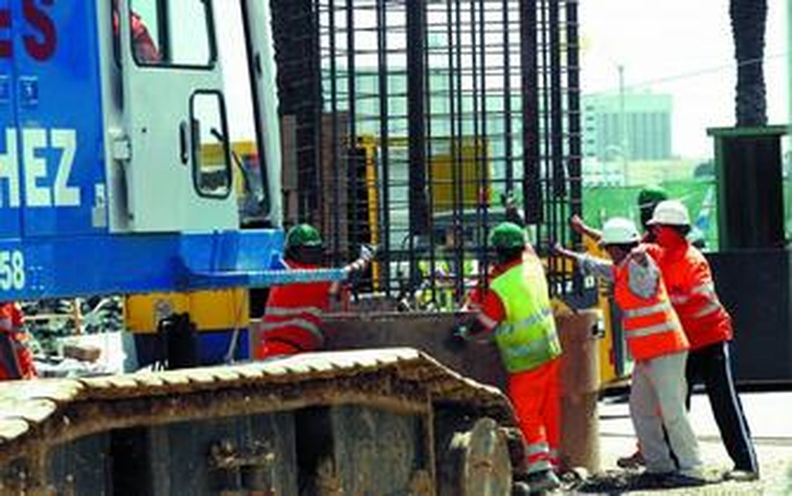 En la imagen, varios operarios ayudan a introducir una armadura en el hueco sobre el que se construirá el estribo de la capital.