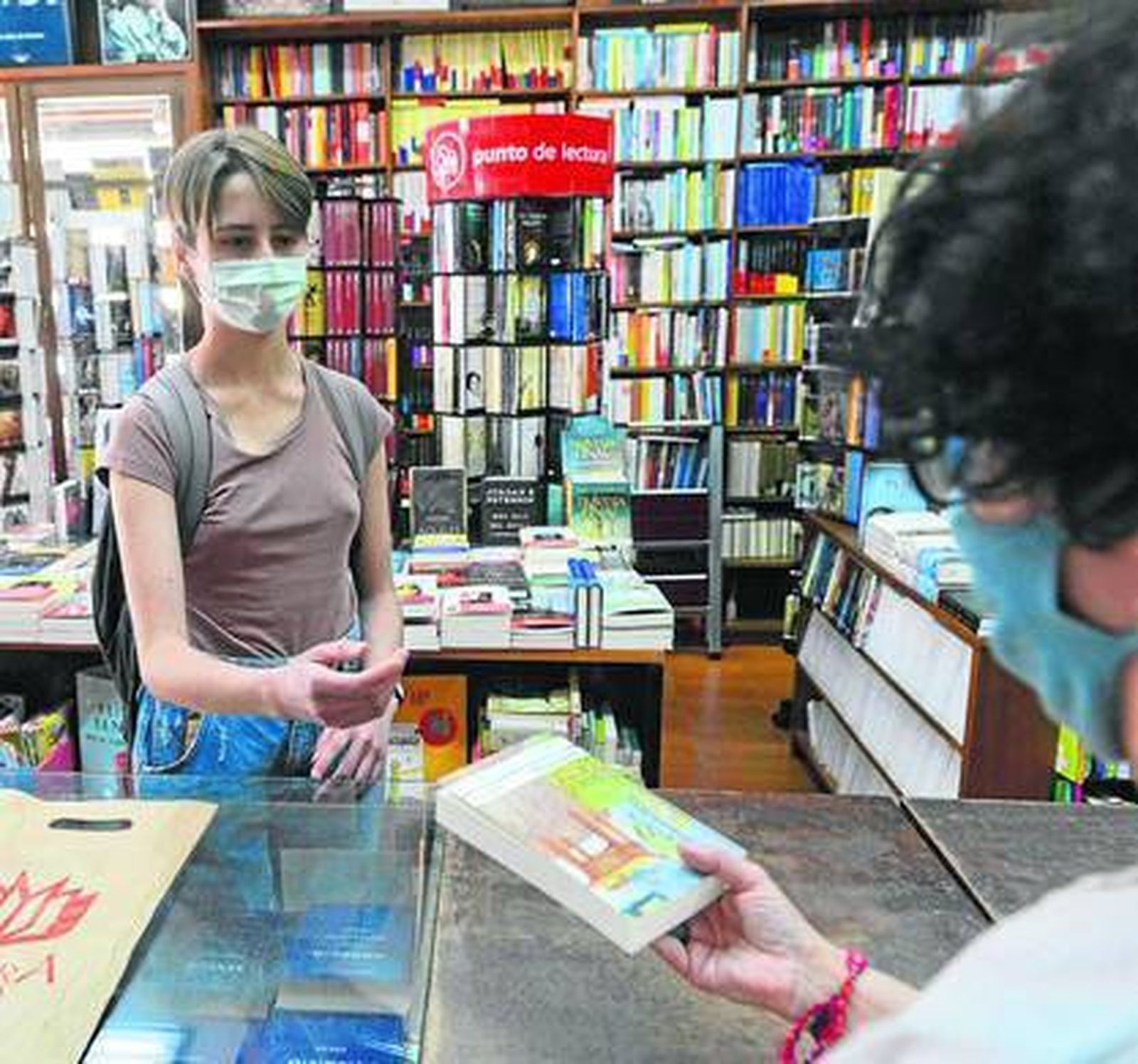Una joven compra un libro en la librería Reguera.