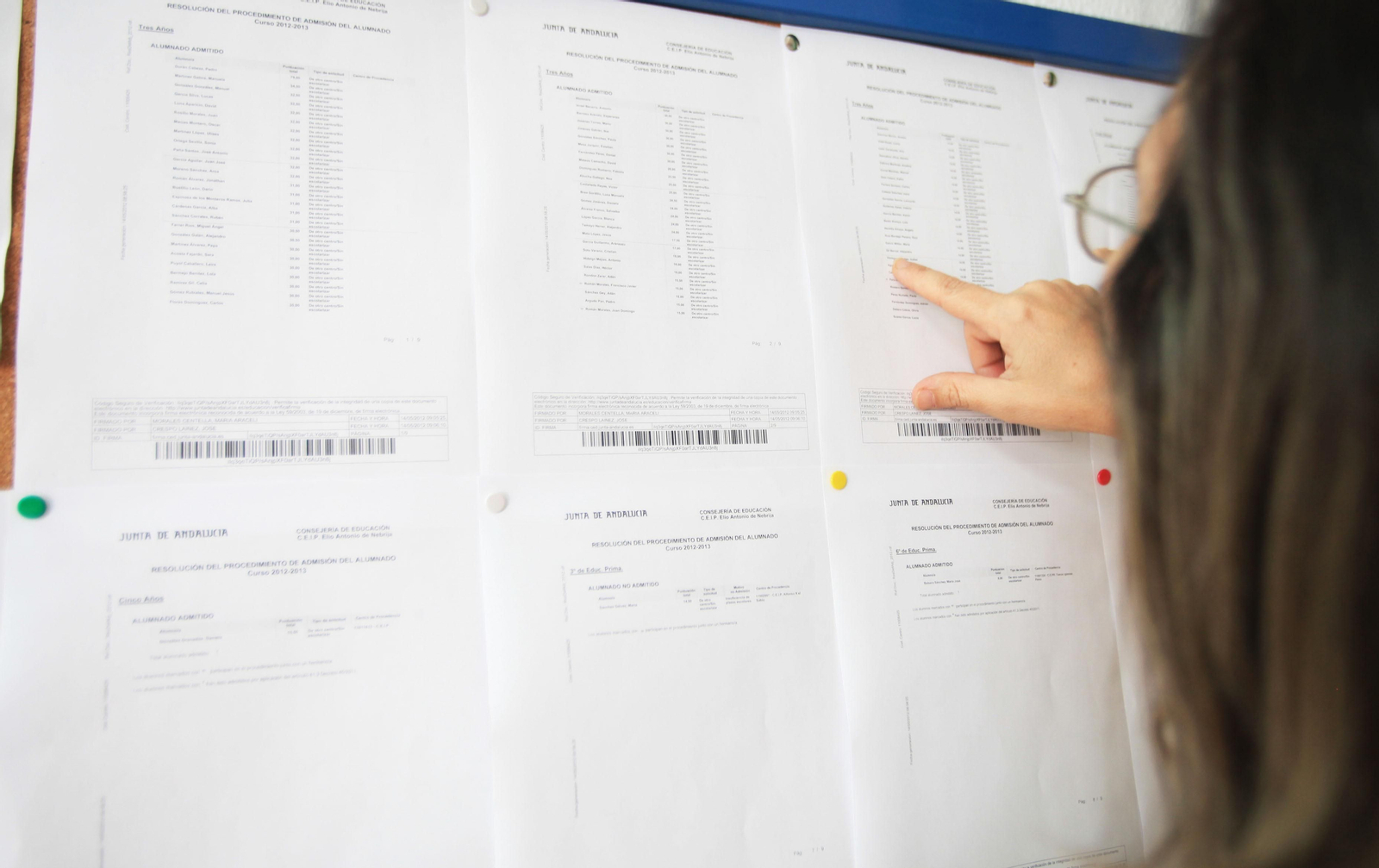 Una mujer, mirando las listas en un centro educativo.