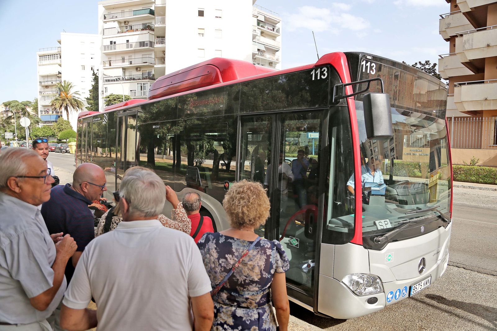 Varias personas esperan para acceder a un autobús nuevo ayer en el parque de El Retiro.